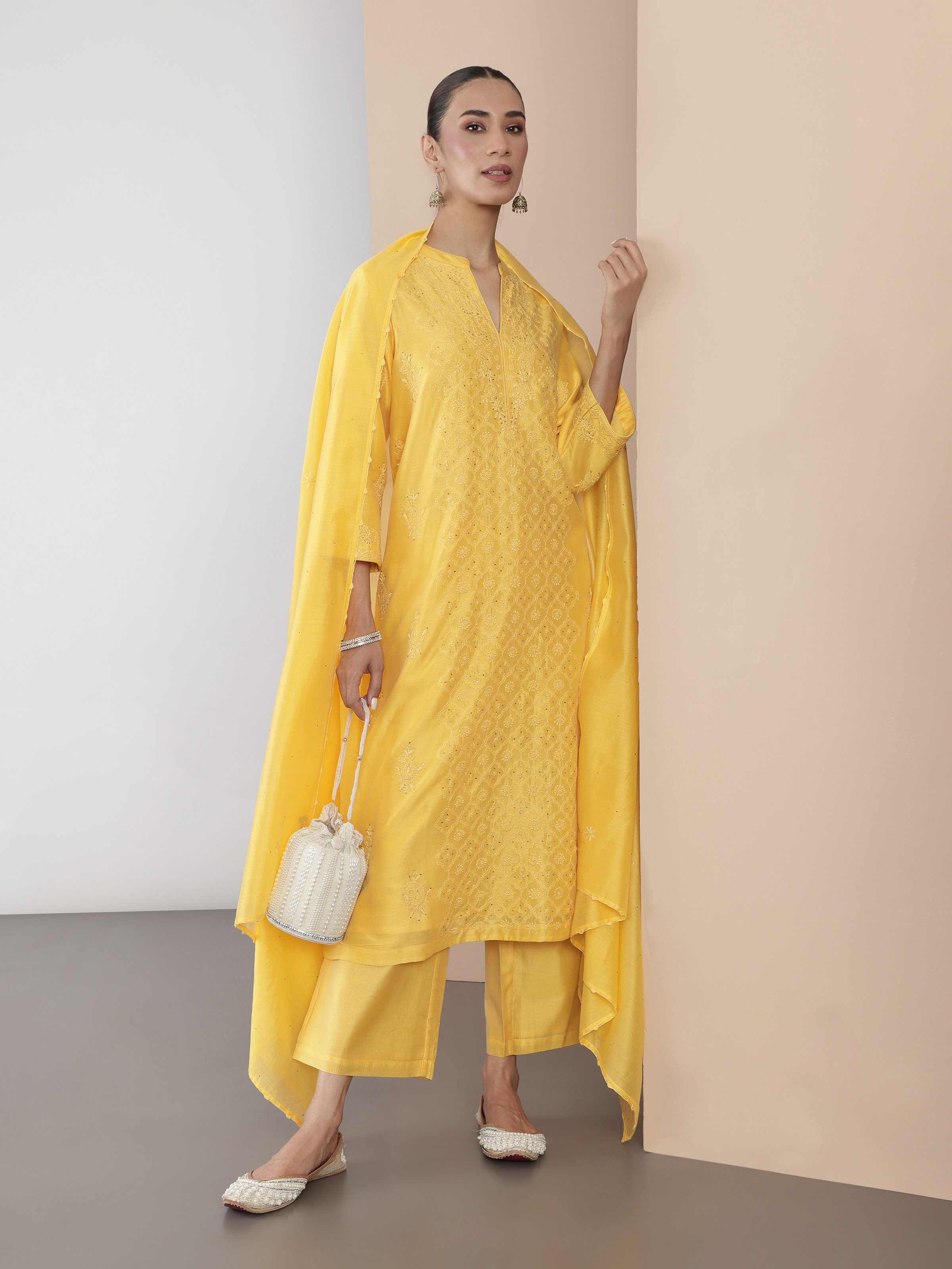 Front detailed view of model showcasing the full yellow Chikankari kurta set in a graceful standing pose.