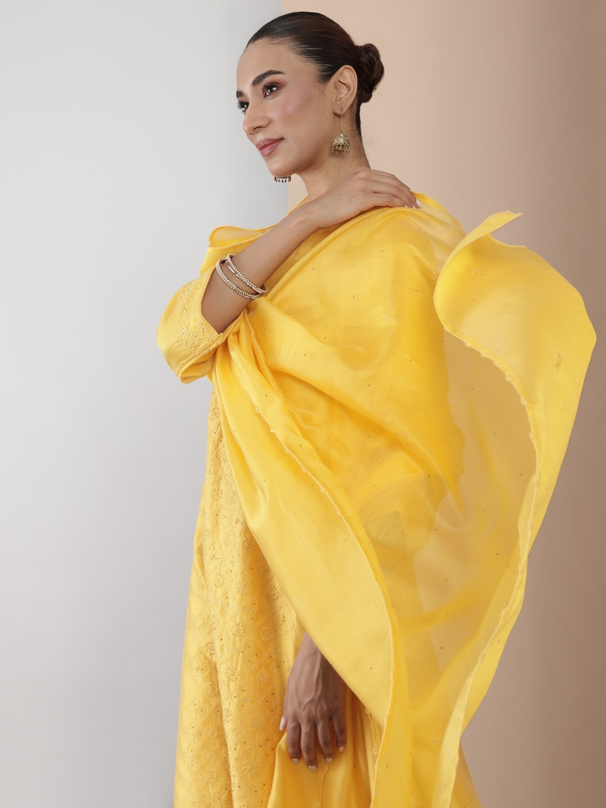 Side view of the yellow silk kurta highlighting delicate Chikankari work and flowing silhouette.