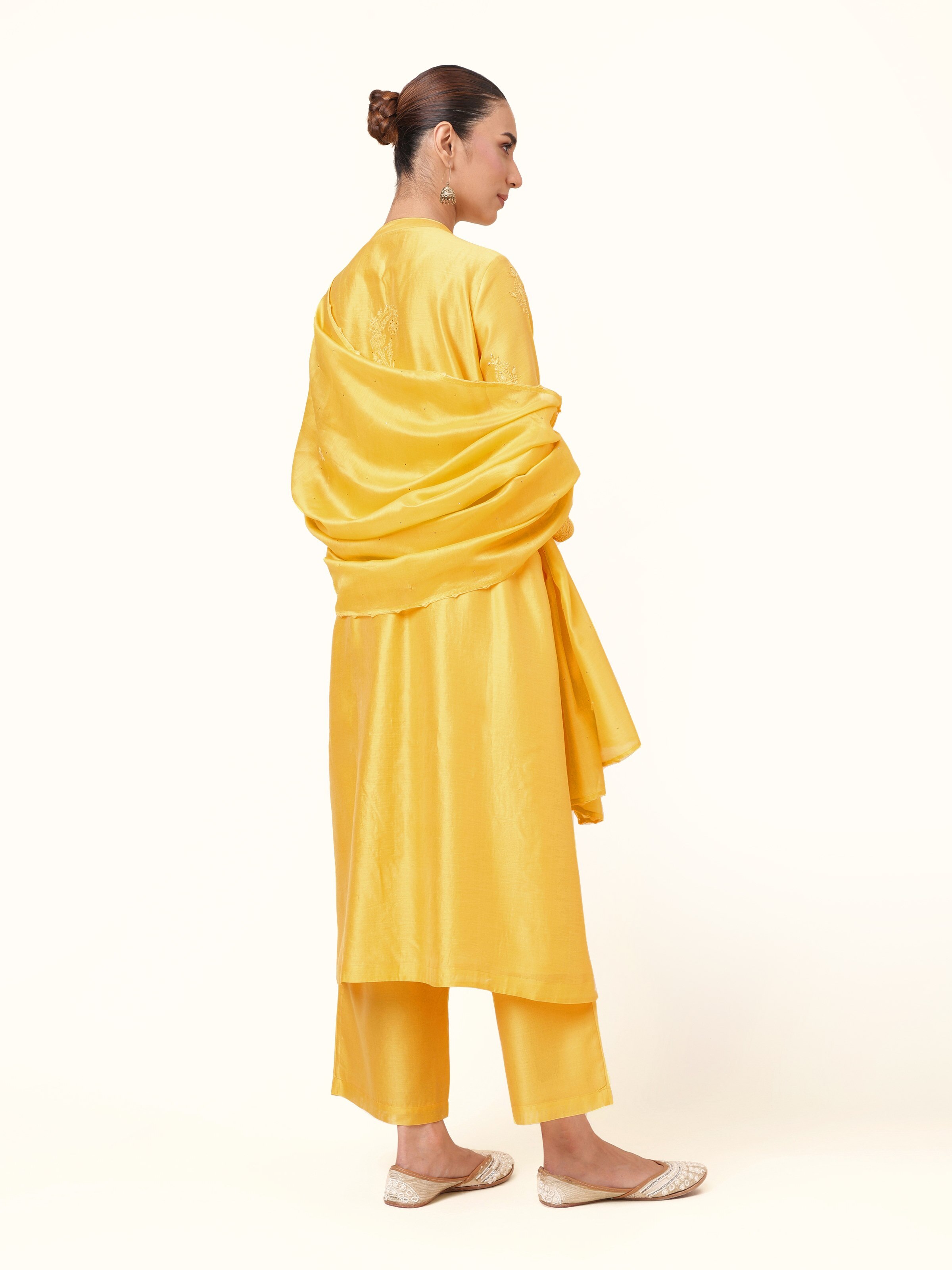 Back view of yellow silk kurta set emphasizing the smooth fabric and elegant design from behind.