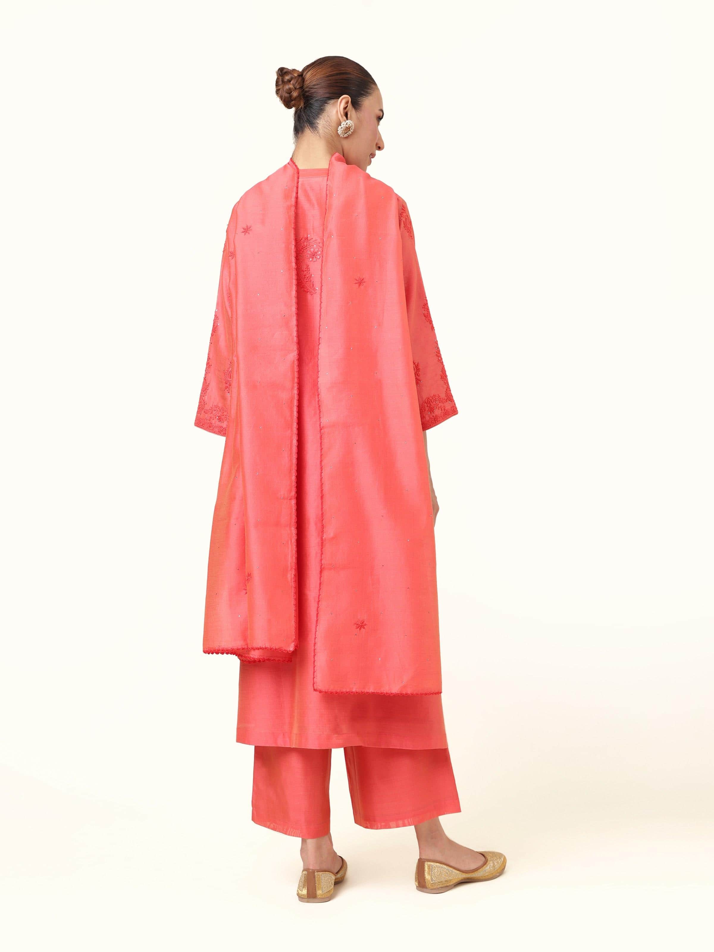 Back view of coral orange silk kurta set with embroidery on the rear yoke.