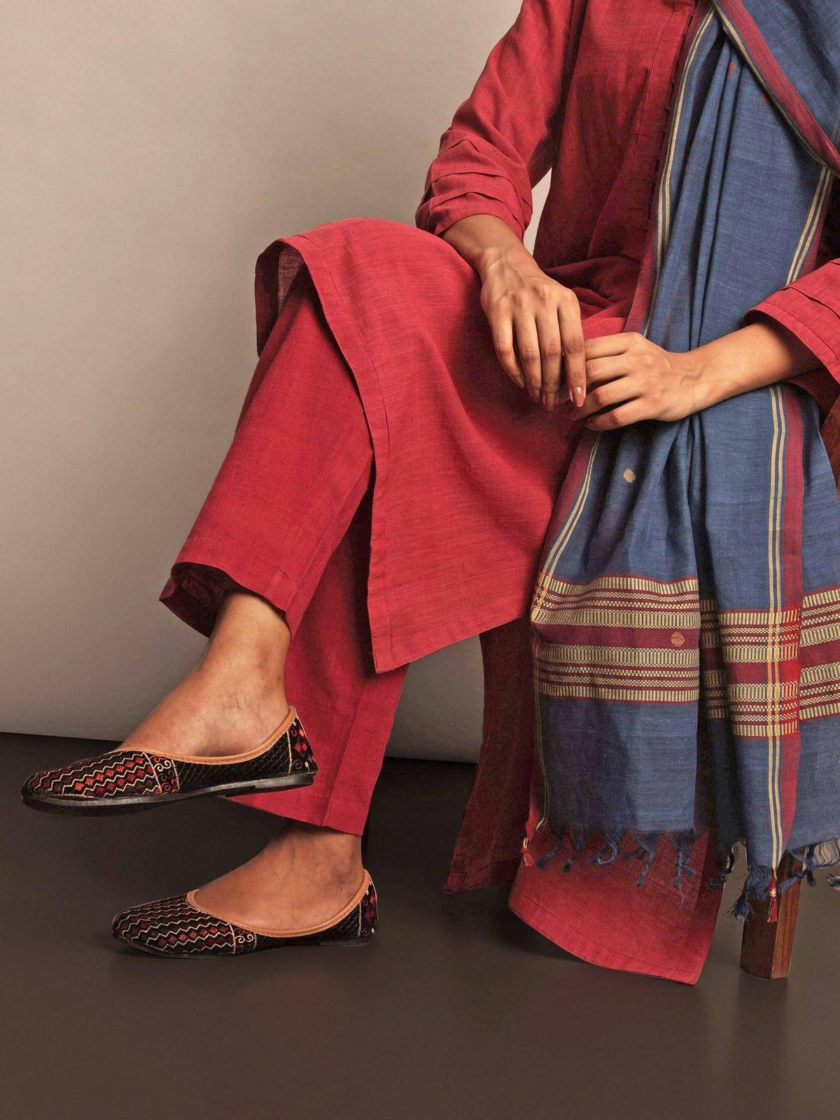 Side lifestyle view of red cotton straight-fit pant showing relaxed silhouette and ankle length