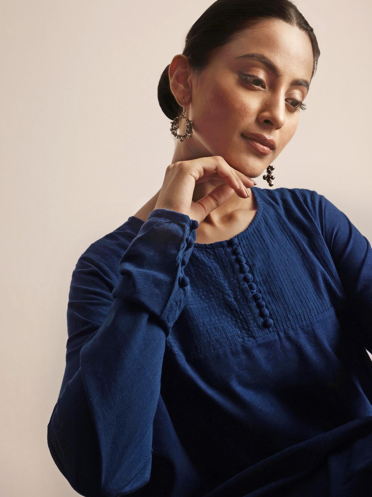 Overhead lifestyle view capturing neckline and gathered flare of indigo cotton kurta