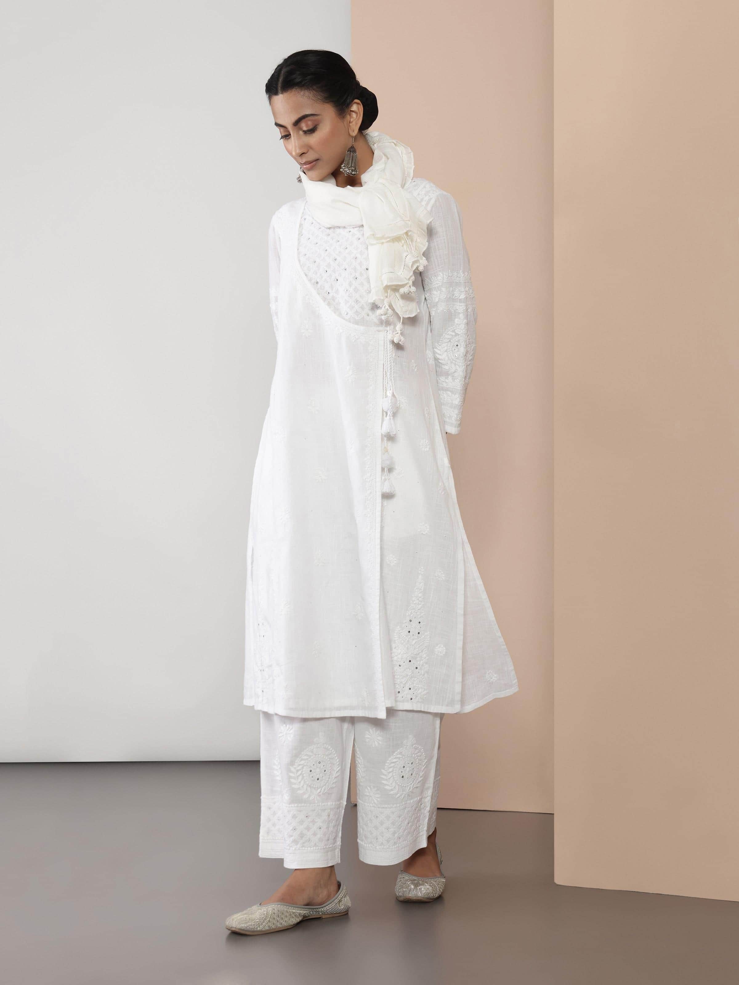 Lifestyle view of white cotton Chikankari kurta styled with minimal accessories in a modern indoor setting.