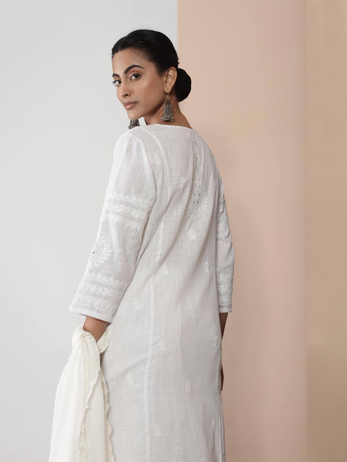 Angled lifestyle view of white Chikankari kurta showing embroidered details and flowy hemline.