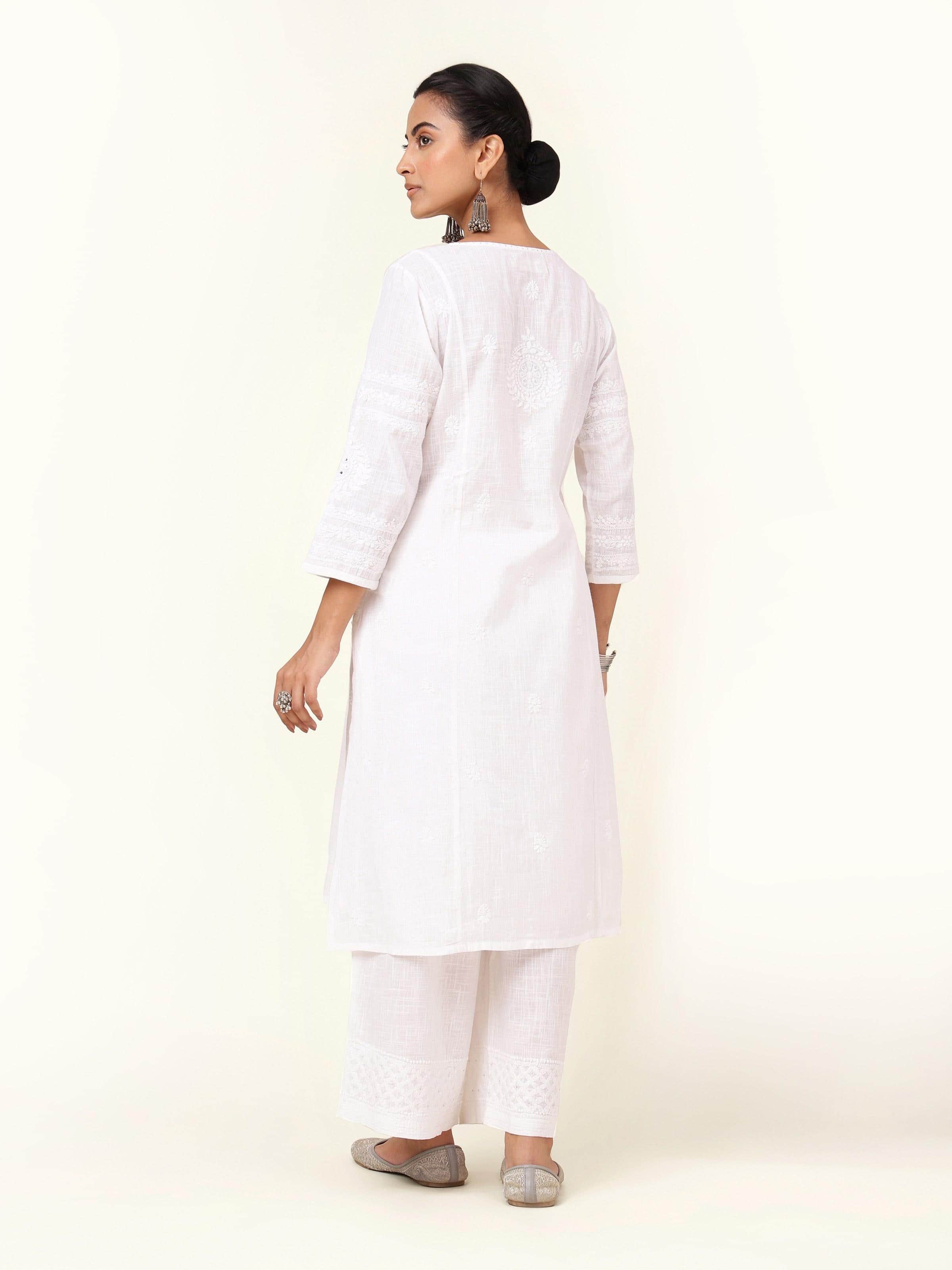 Back view of white cotton A-line Chikankari kurta showcasing panel detailing and relaxed structure.