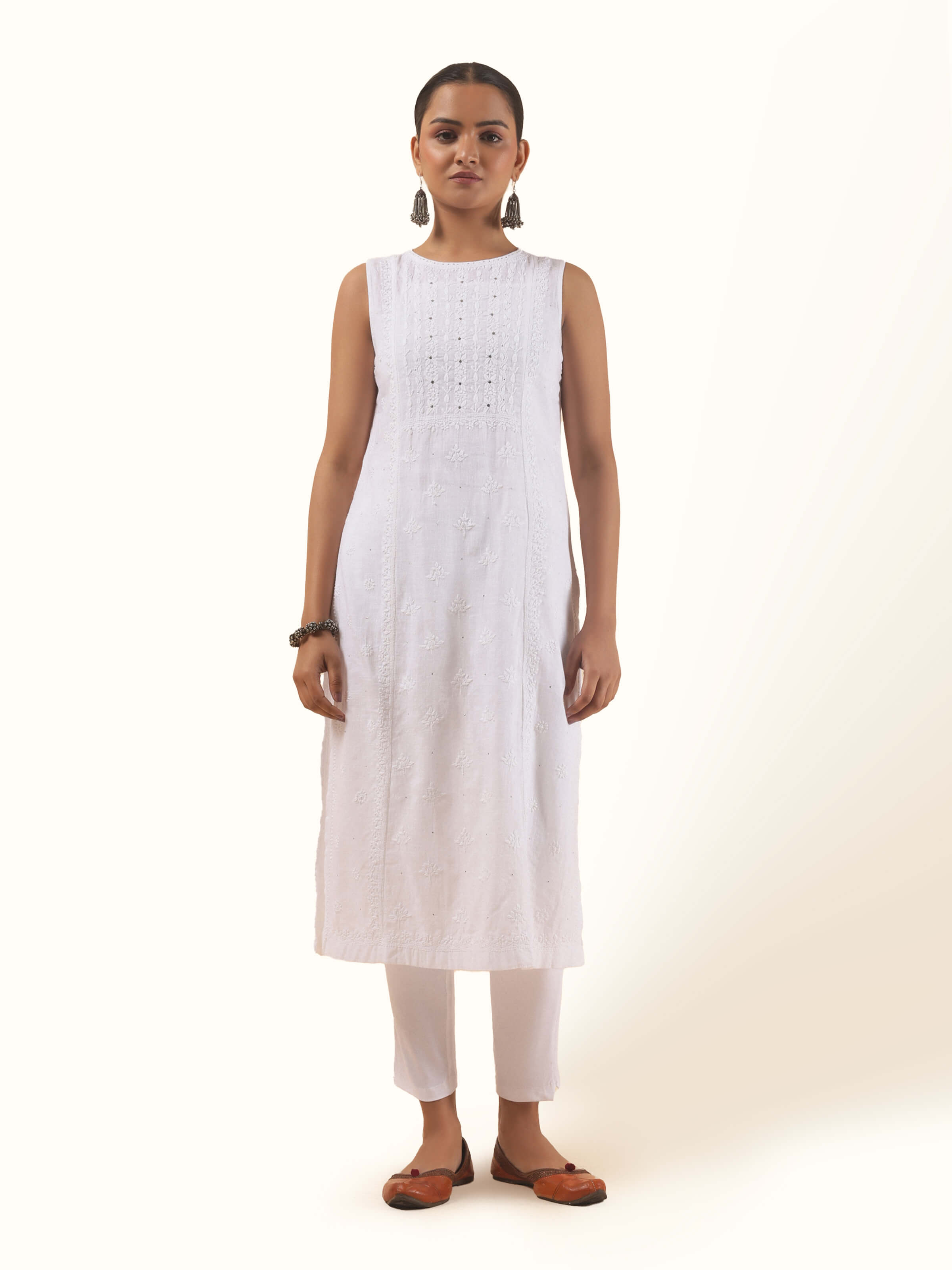 Front view of white cotton Chikankari sleeveless kurta with delicate floral embroidery and keyhole neckline