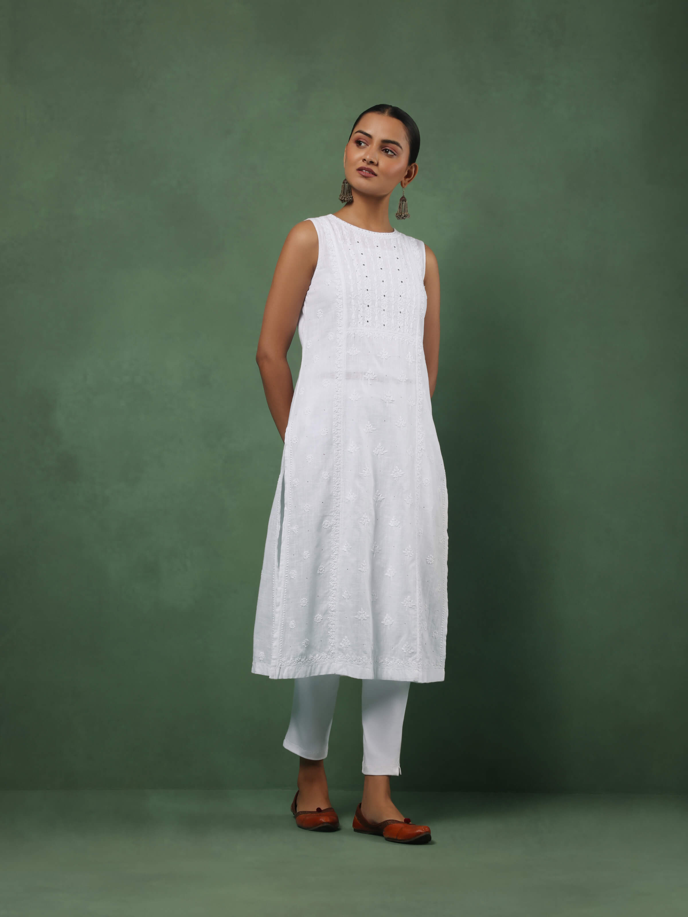 Lifestyle view of white Chikankari kurta styled with palazzos and silver earrings for an elegant casual look
