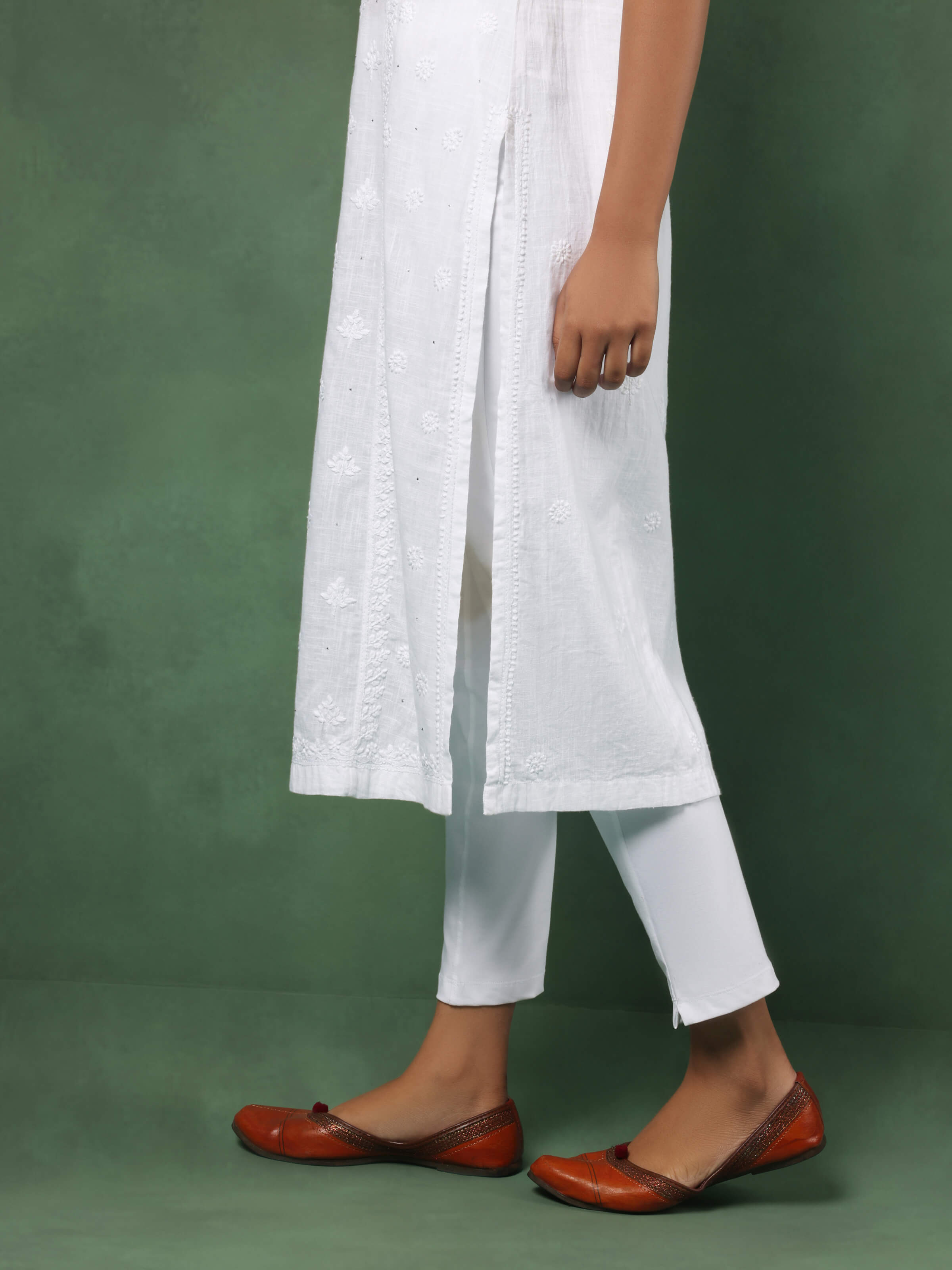 Detail shot of neckline and embroidery on white sleeveless Chikankari kurta showcasing intricate threadwork