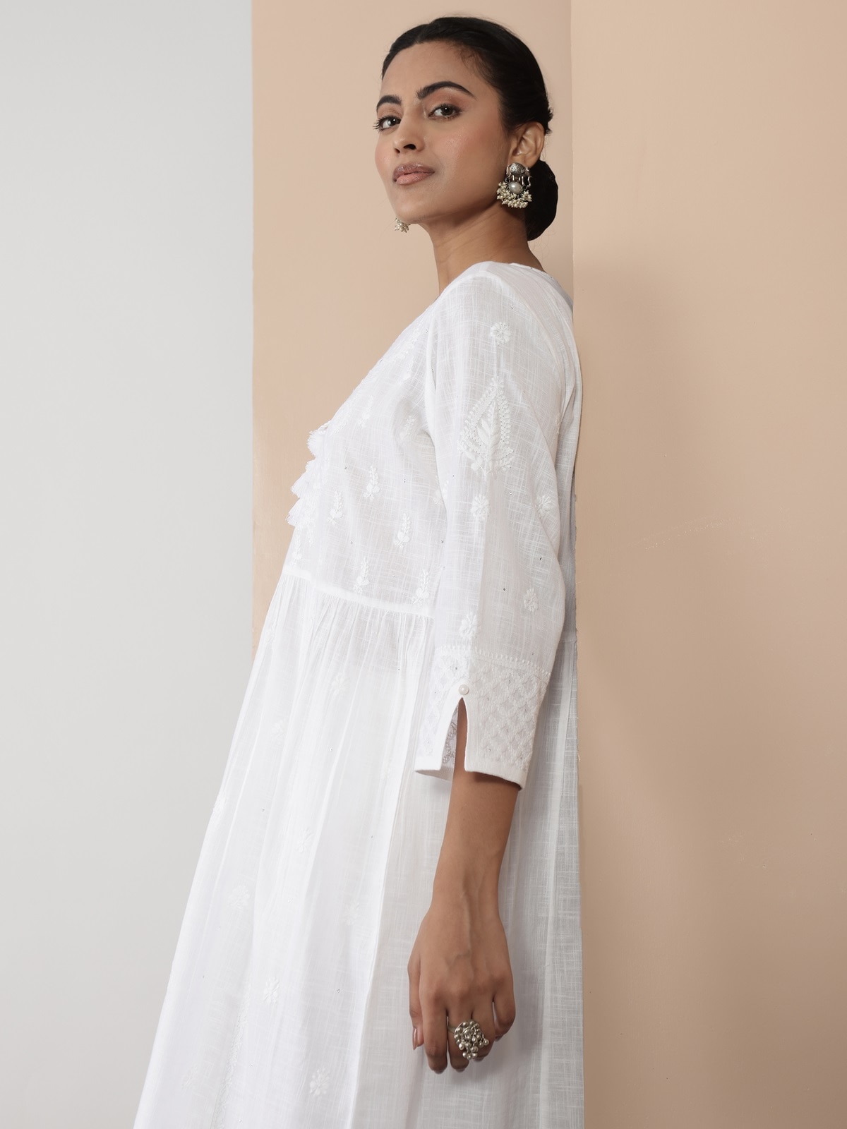 Close-up of chikankari embroidery on white cotton kurta emphasizing fine handiwork.