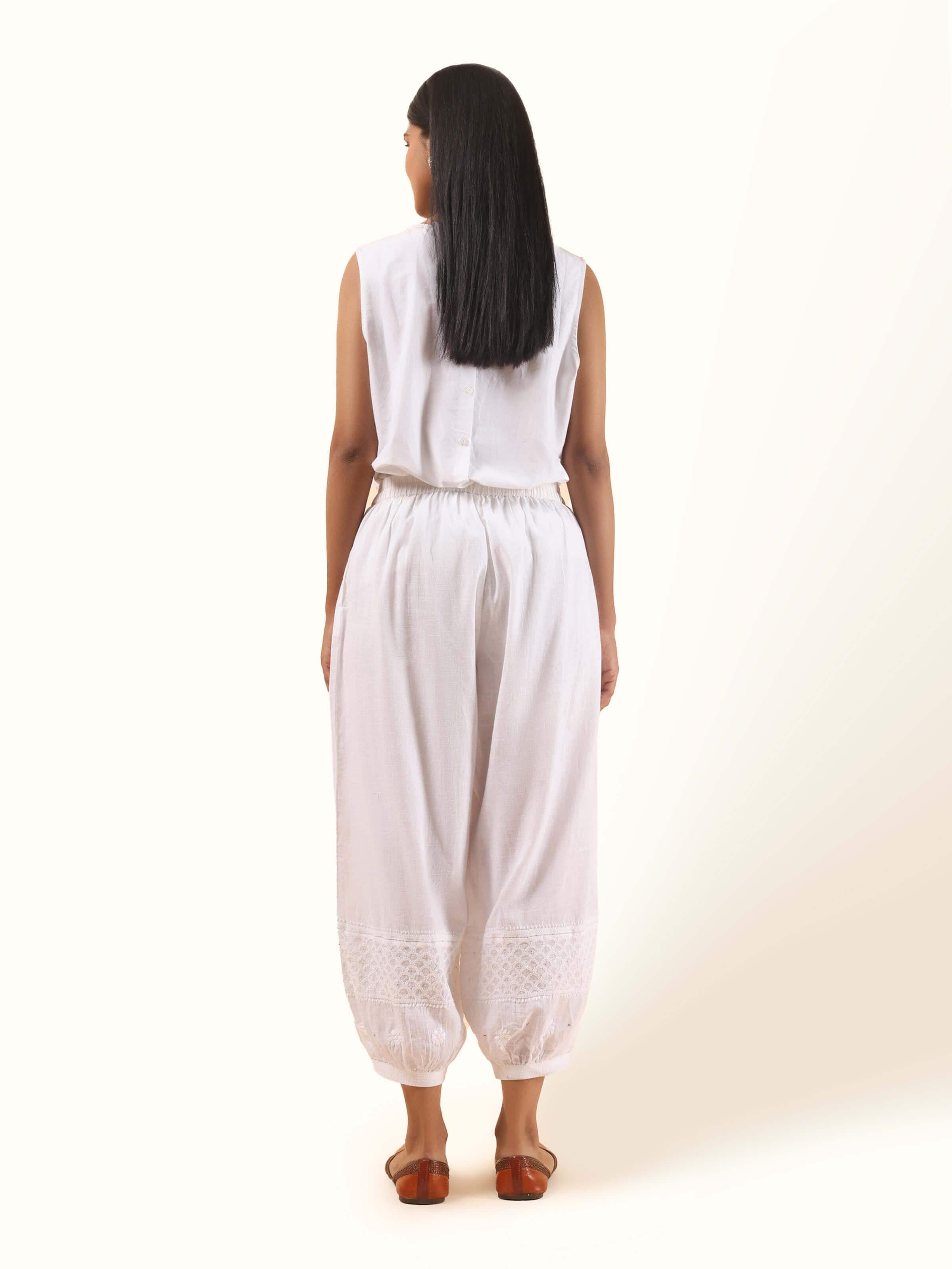 Back view of white cotton chikankari harem pants paired with a casual top, highlighting the flow and fit of the embroidered pants.