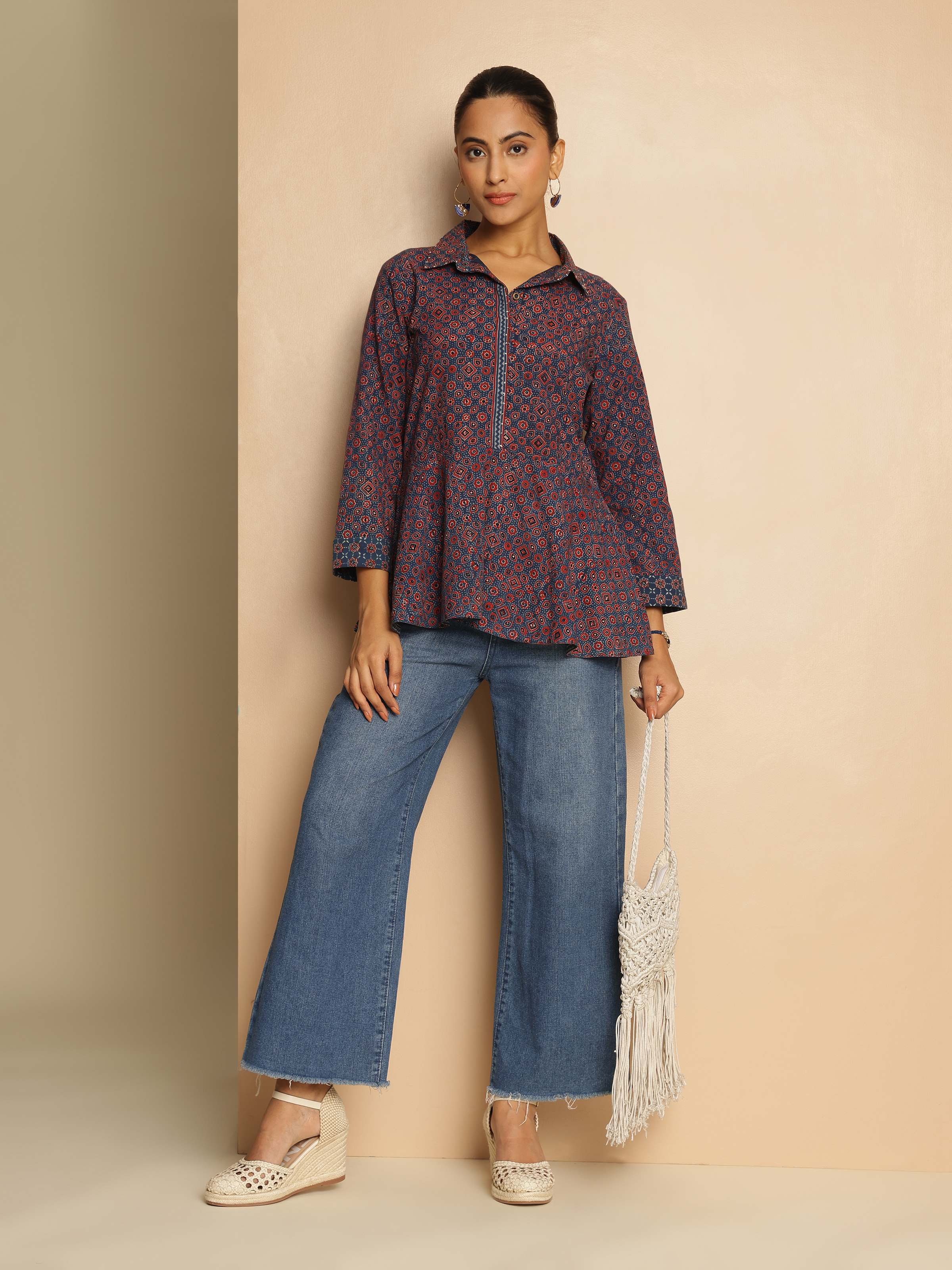Lifestyle view of blue Ajrakh print peplum top paired with contrast trousers