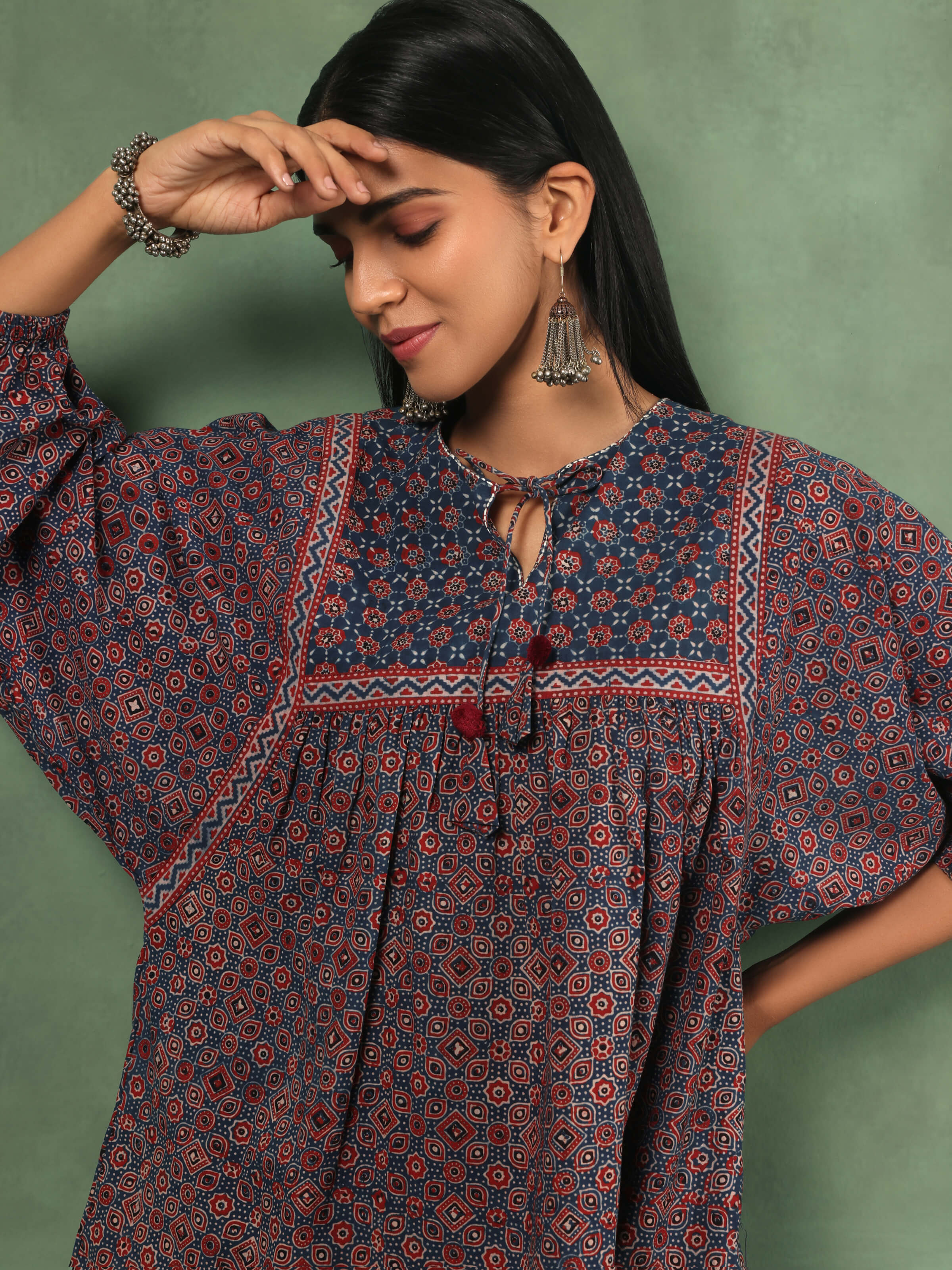 Detail shot of Ajrakh block print on red cotton top highlighting handcrafted design