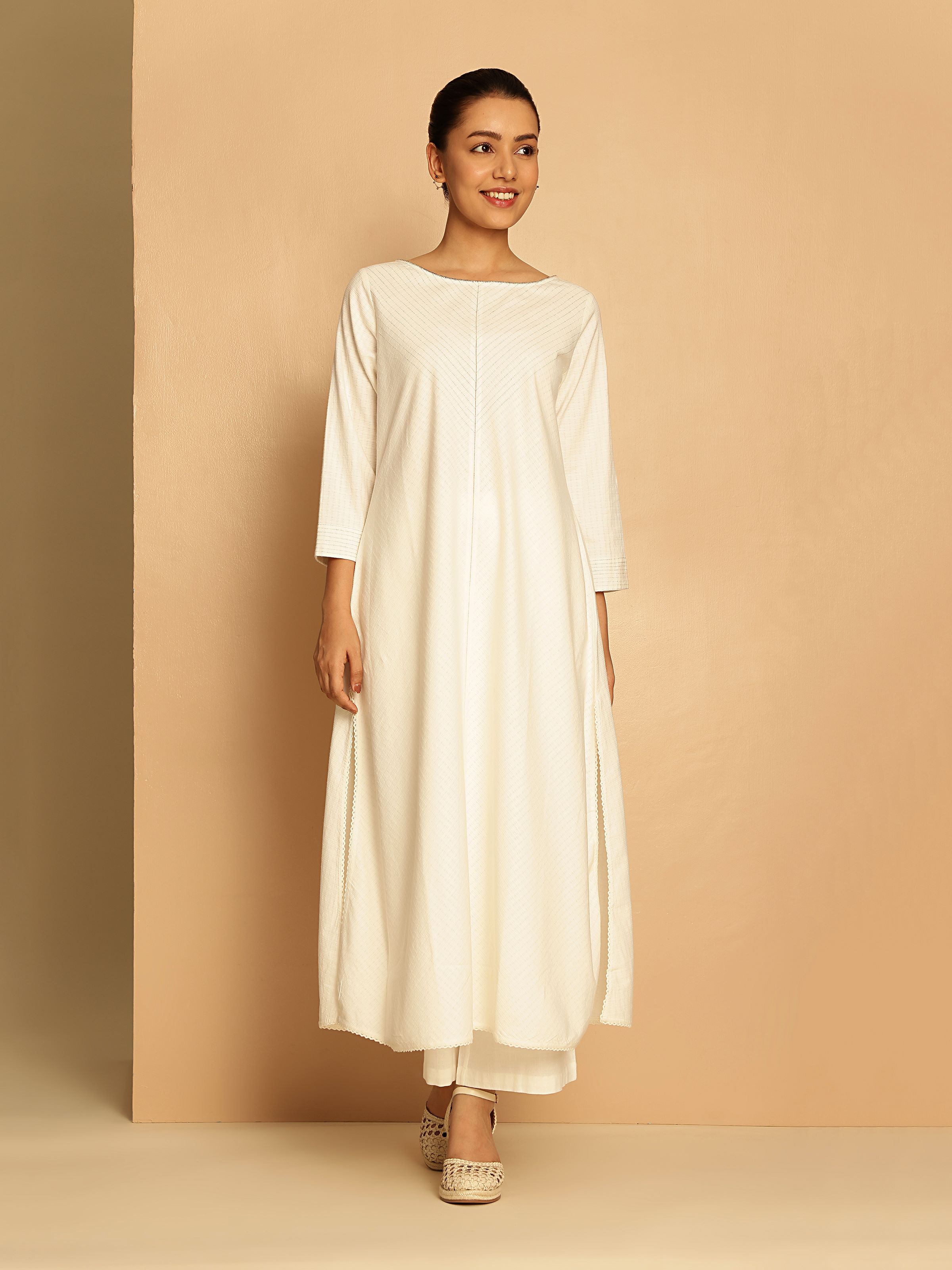 Lifestyle view of off-white cotton kurta styled with classic white trousers