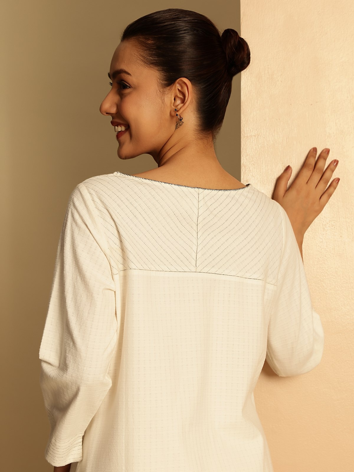 Side lifestyle view of off-white cotton kurta with comfortable silhouette