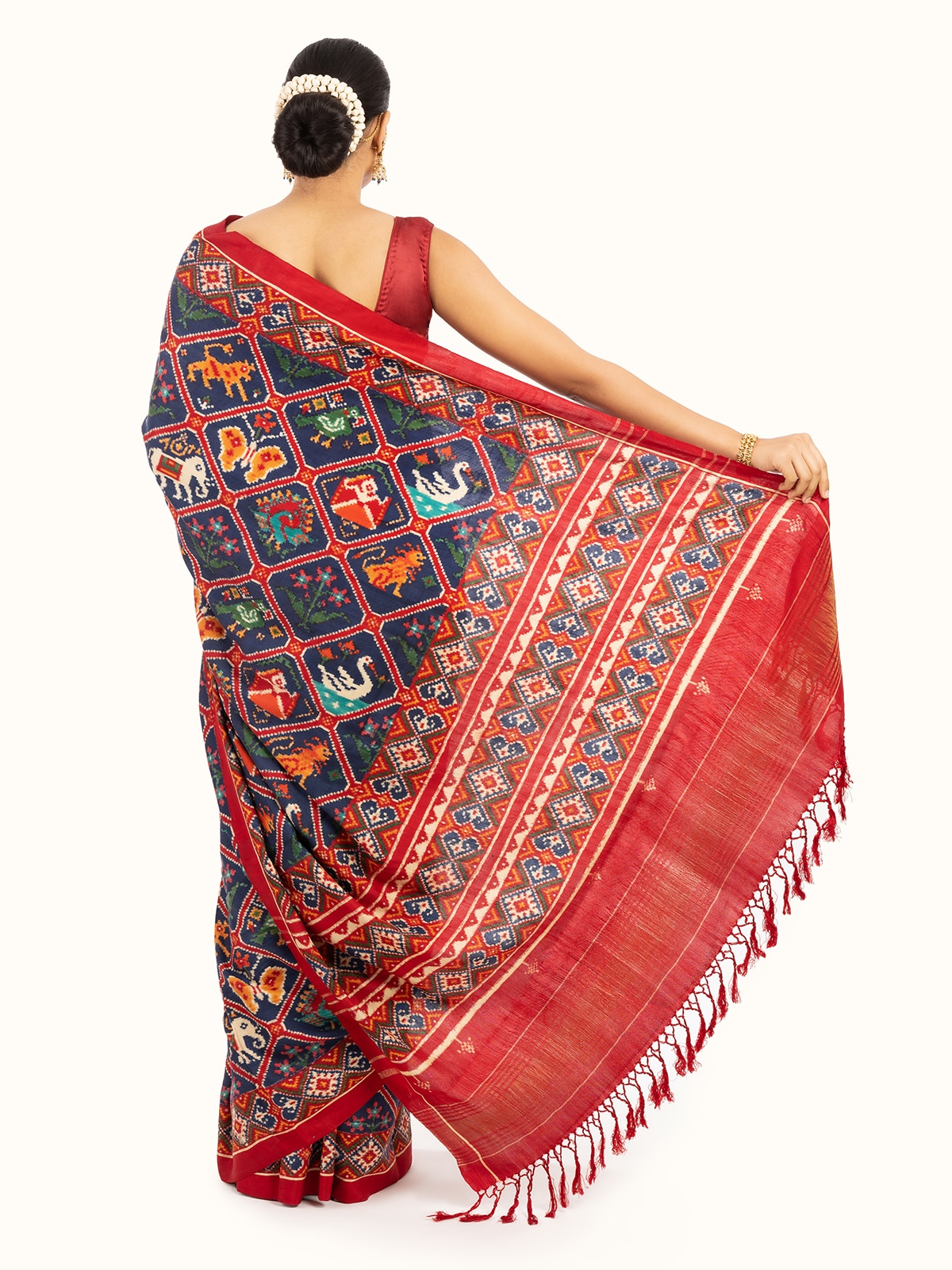 Back view of navy blue mulberry silk patan patola saree displaying intricate pattern details and silk finish