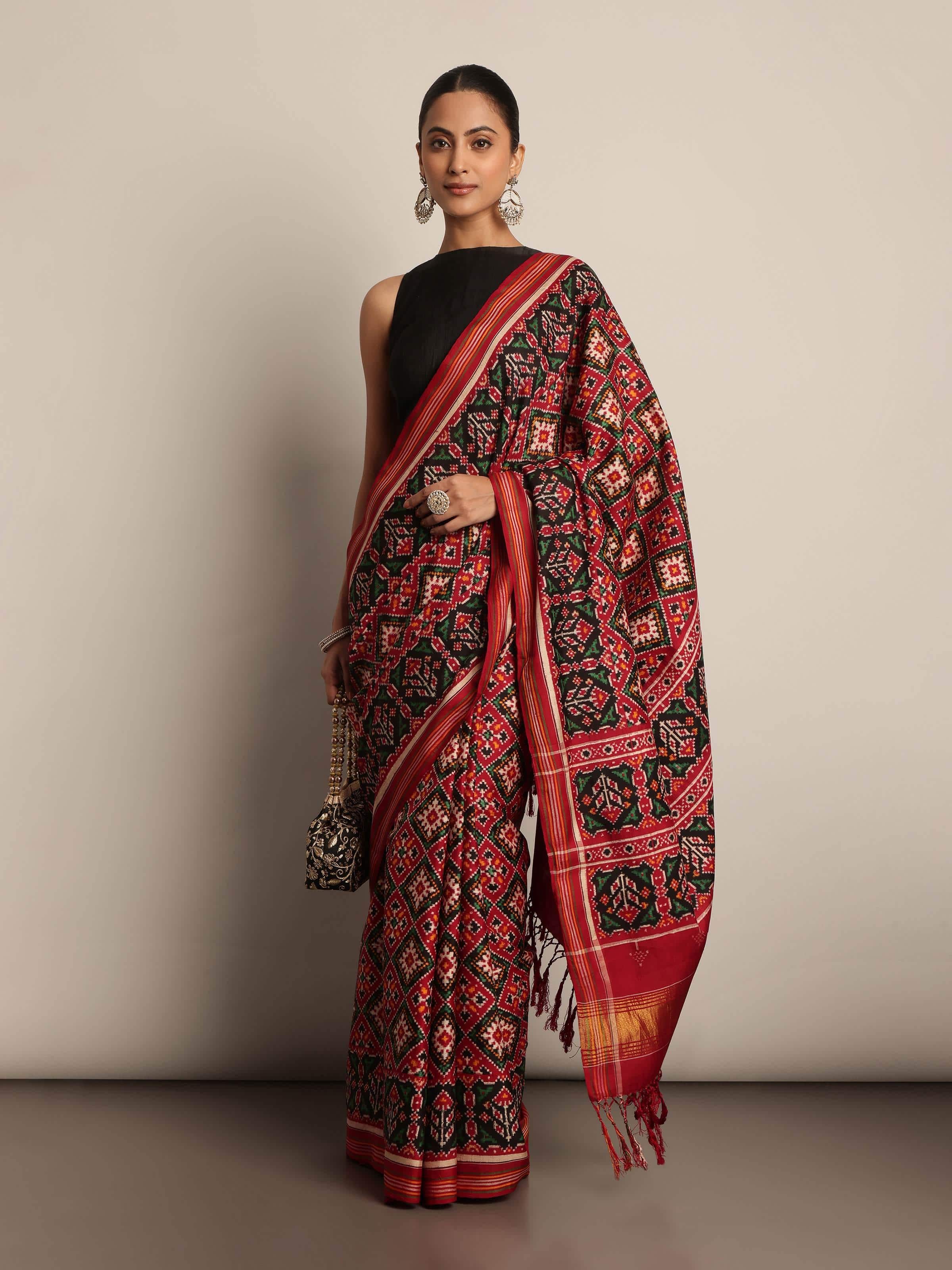 Lifestyle view of Red & Green Mulberry Silk Patan Patola Saree worn by model showcasing rich colors and traditional silk texture.