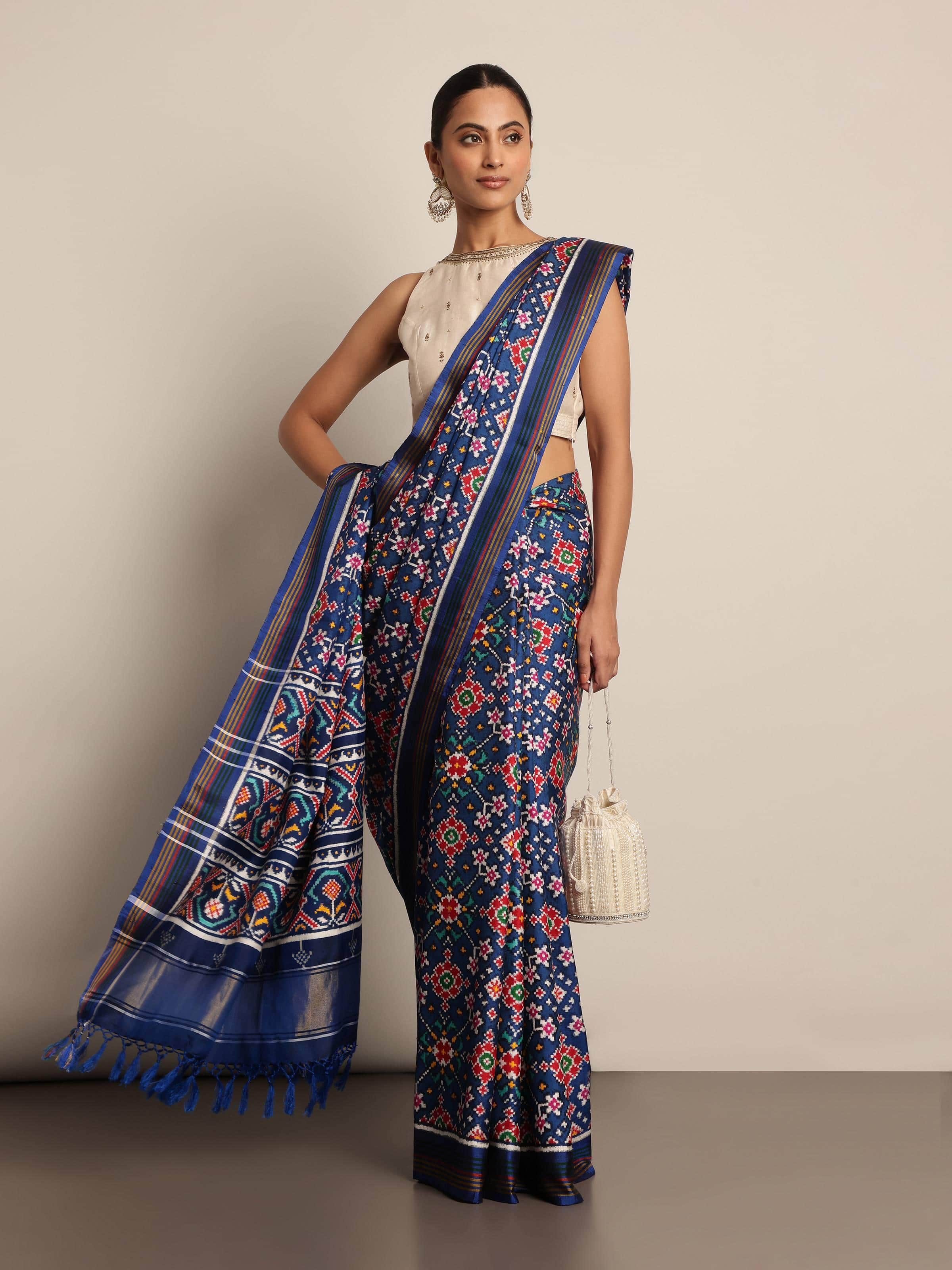 Lifestyle view of blue Patola silk saree styled with contrast blouse and accessories.