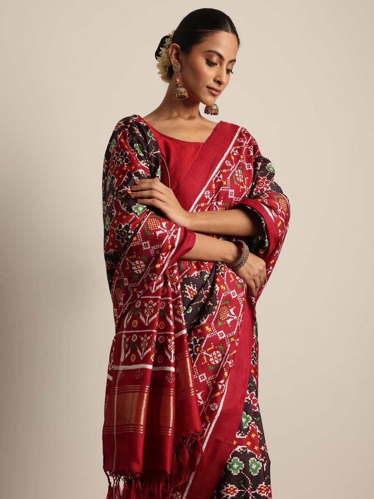 Angled view highlighting rich black silk fabric and Patola handwoven motifs