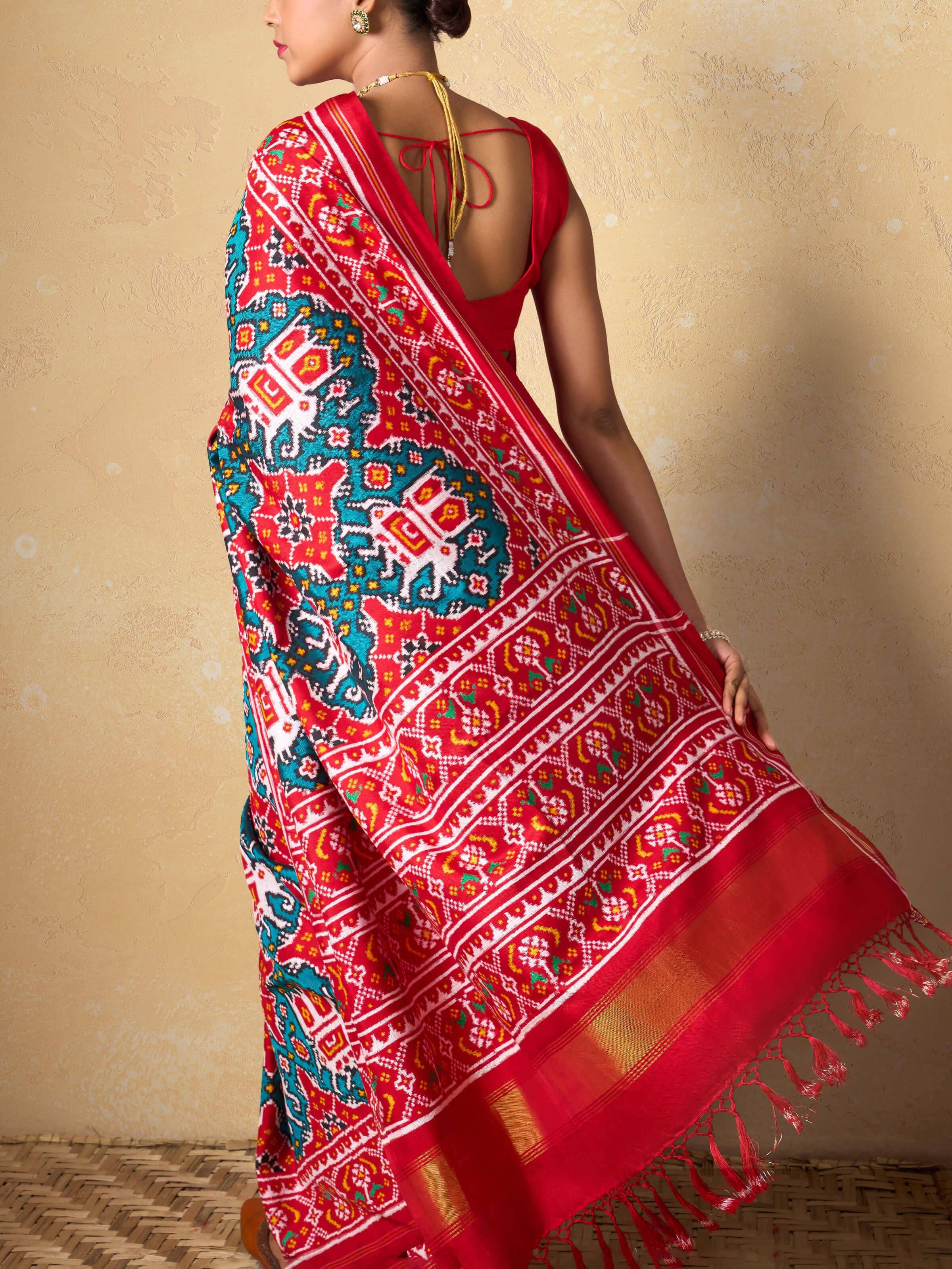 Angled view highlighting silk sheen and woven patterns of Patola saree.