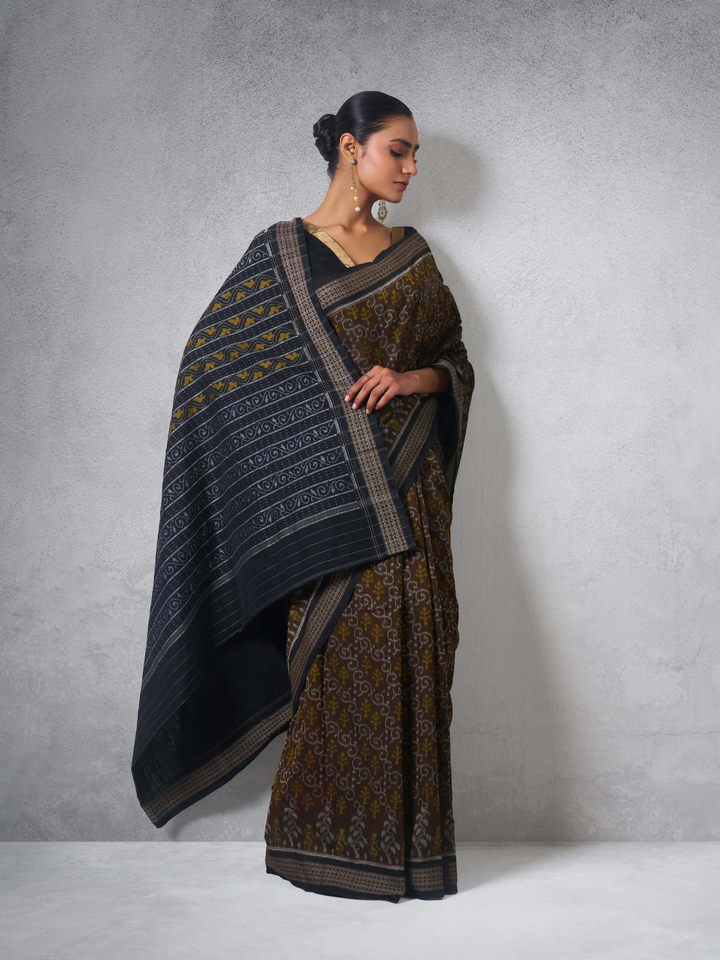 Lifestyle view of Brown Cotton Bandha Odisha Ikat Saree draped highlighting the intricate Ikat designs