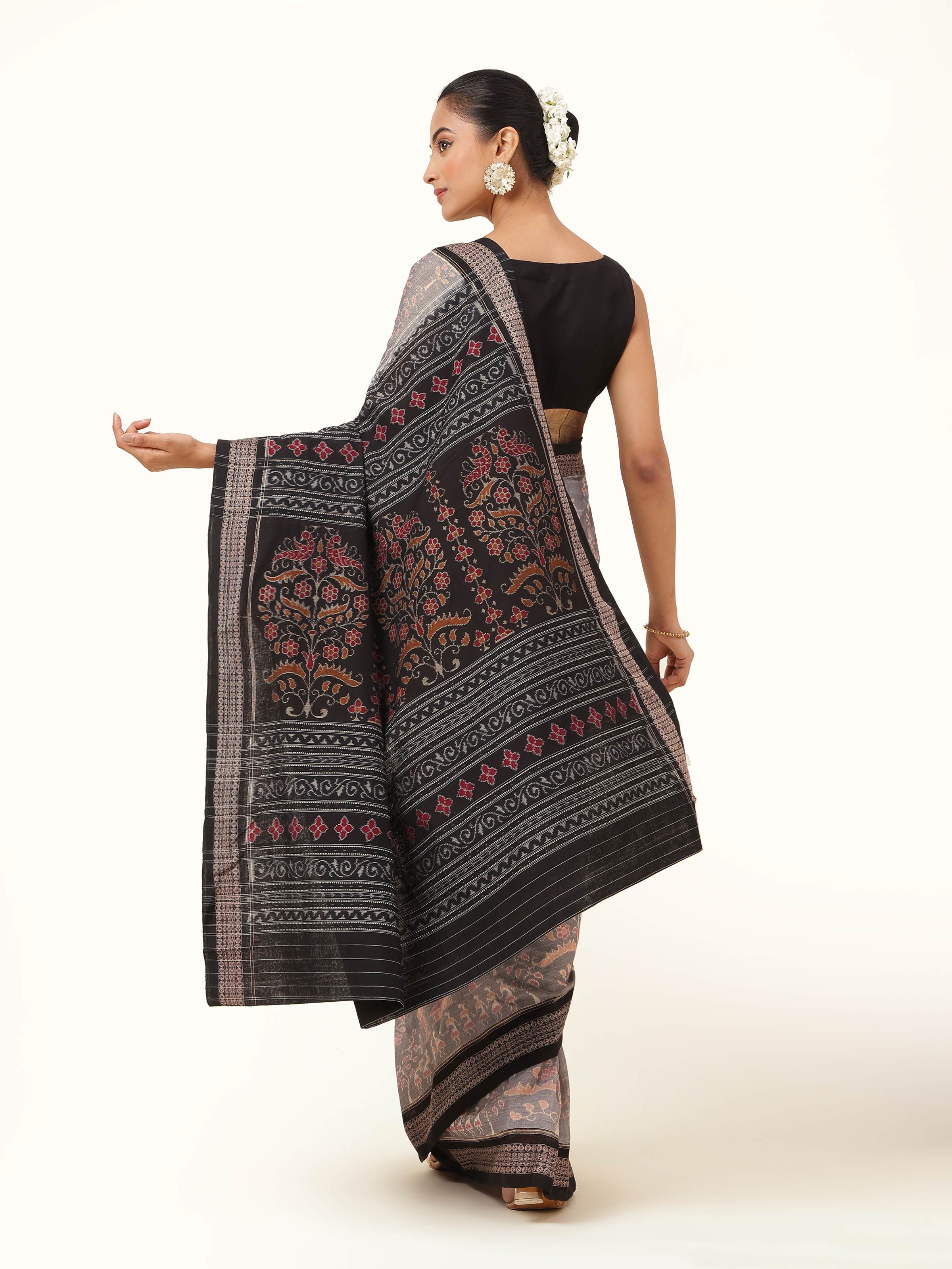 Back view presenting full saree length and detailed Ikat motifs.