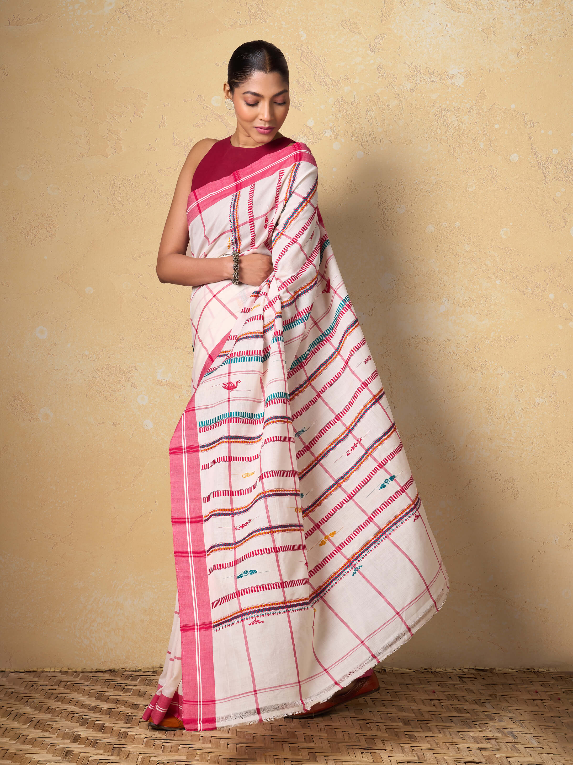 Angled view of red extra-weft cotton saree highlighting pallu design and weaving texture.