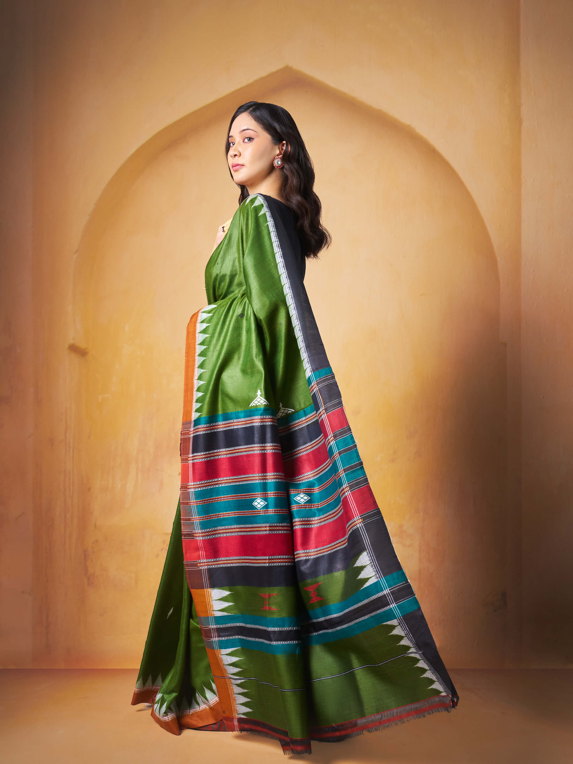 Lifestyle view of the saree styled traditionally with gold jewelry.