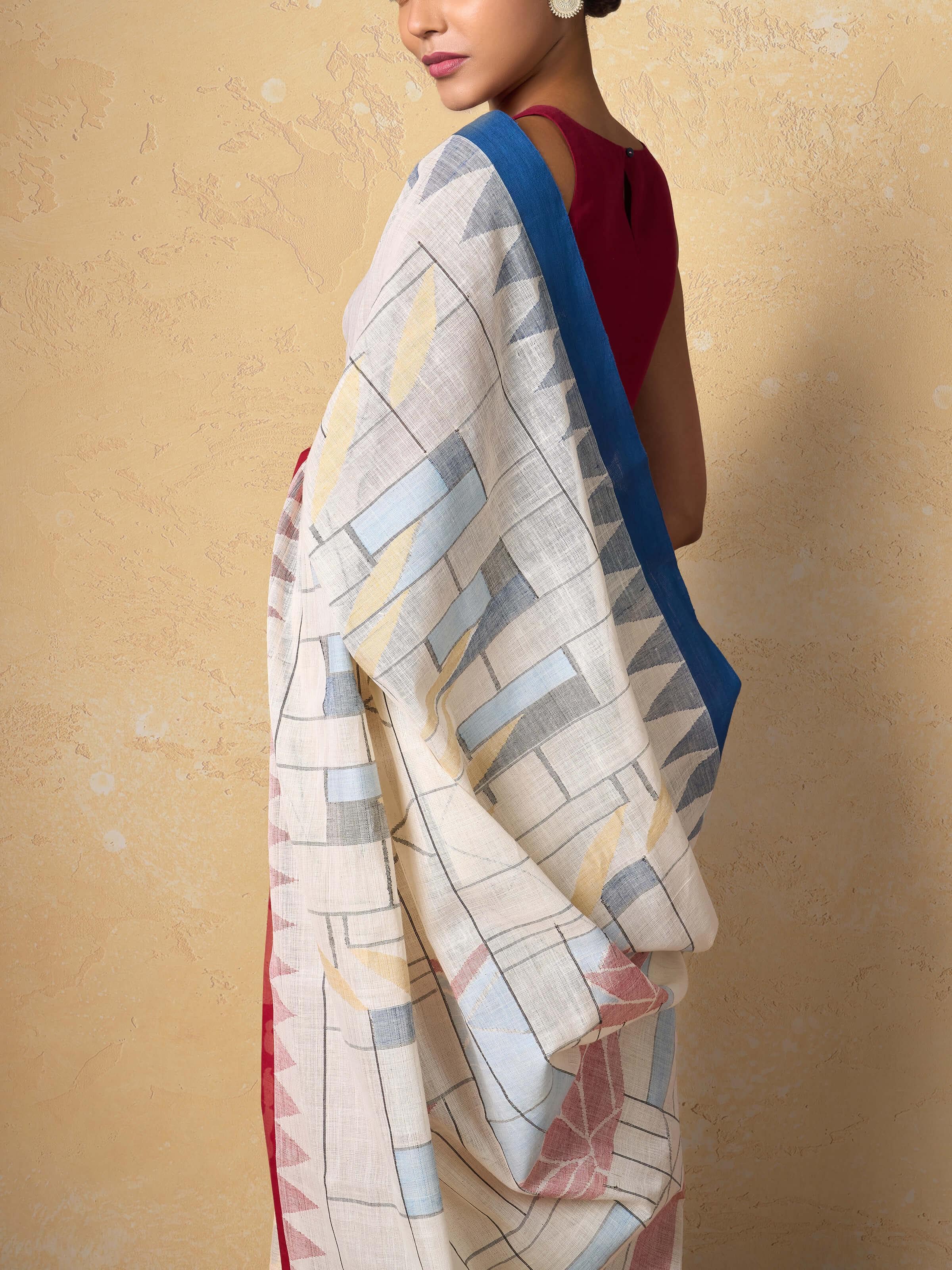 Angled shot of off-white Jamdani saree highlighting the fine weave and airy cotton fabric.