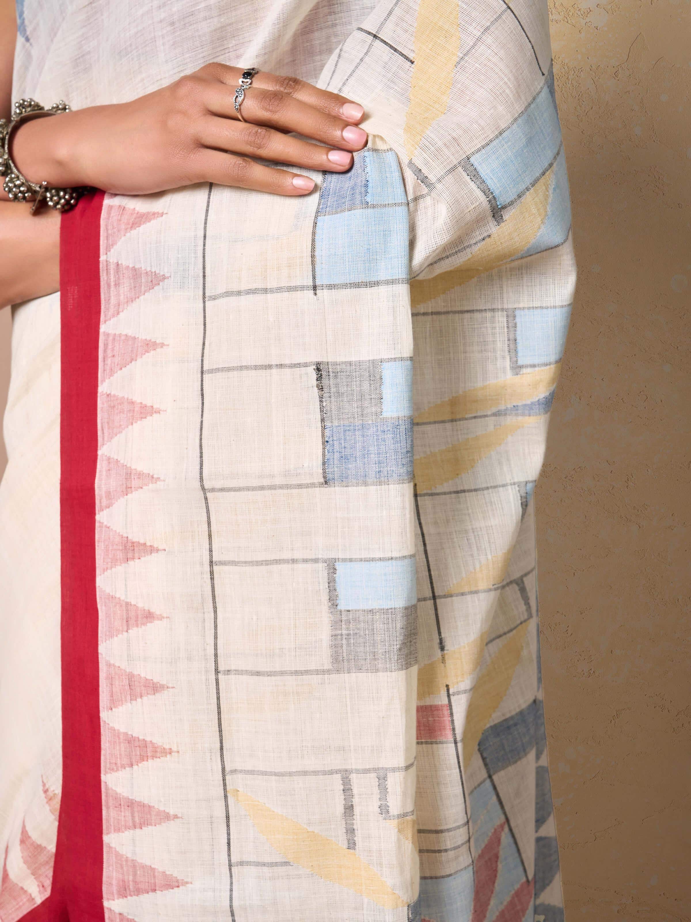 Dynamic side view of off-white cotton Jamdani saree showing movement and handcrafted texture.