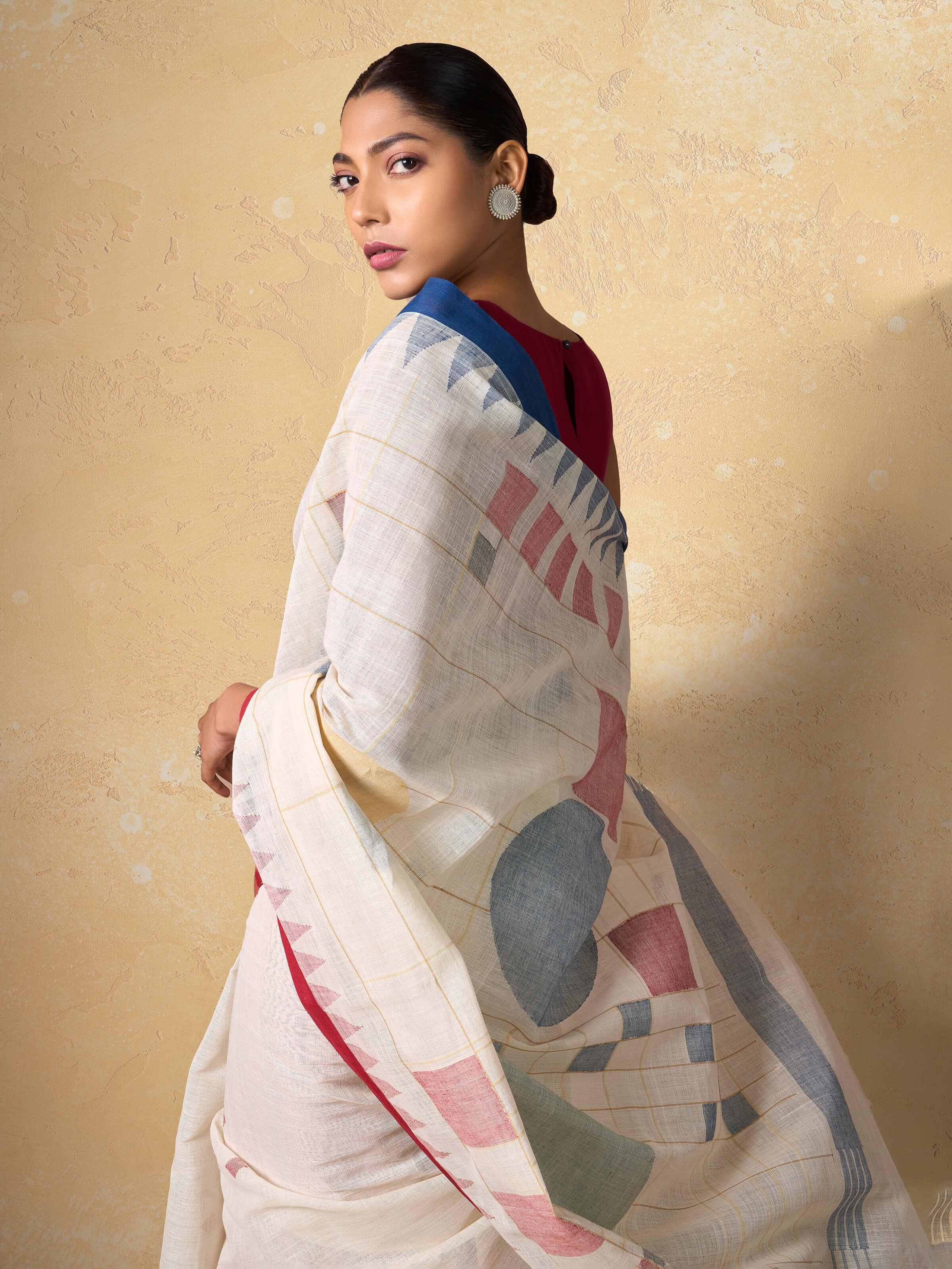 Close-up detail of handwoven Jamdani motifs and cotton threads on white saree