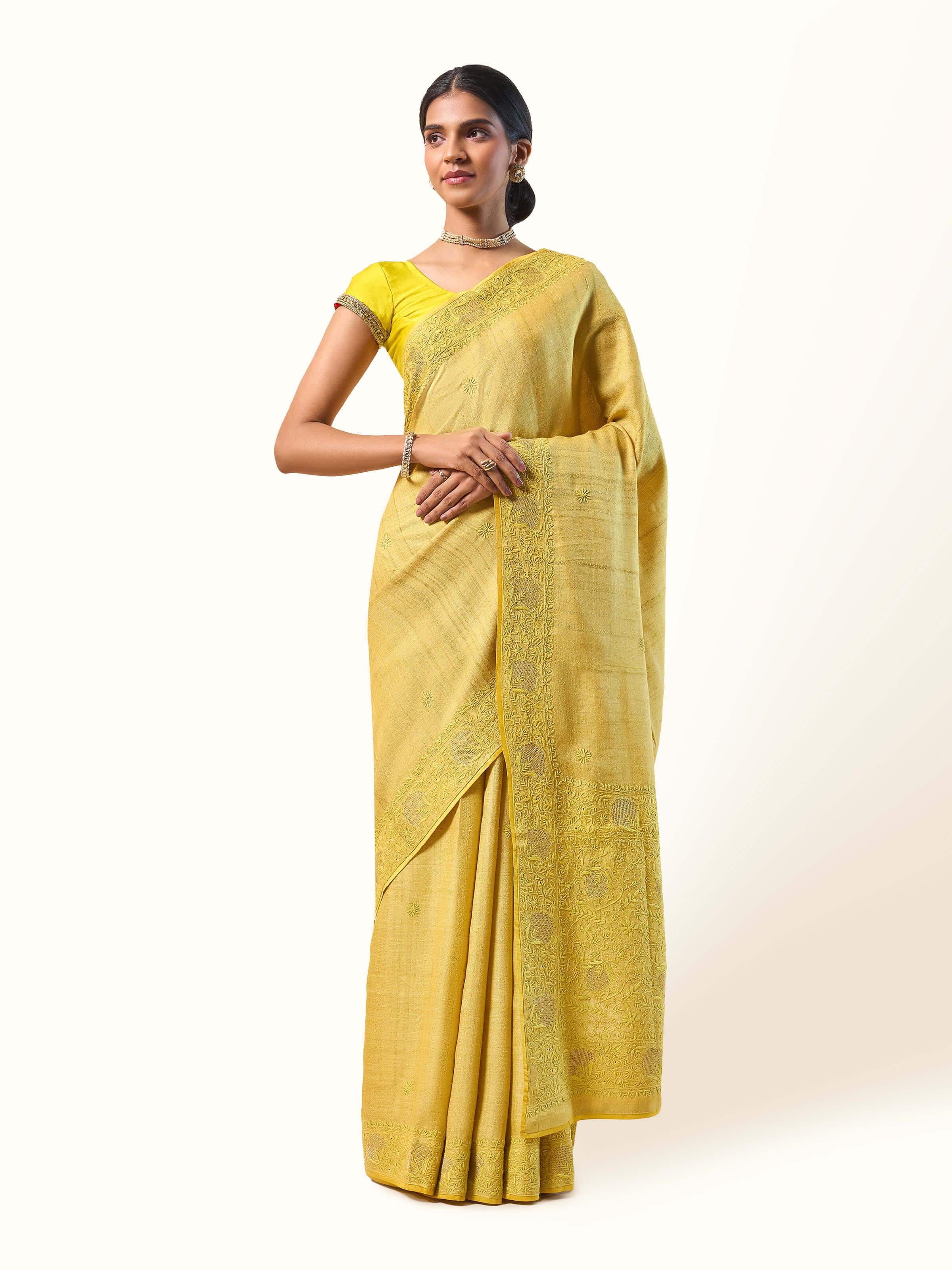 Front view of the graceful yellow silk saree featuring delicate chikankari embroidery and rich traditional detailing.