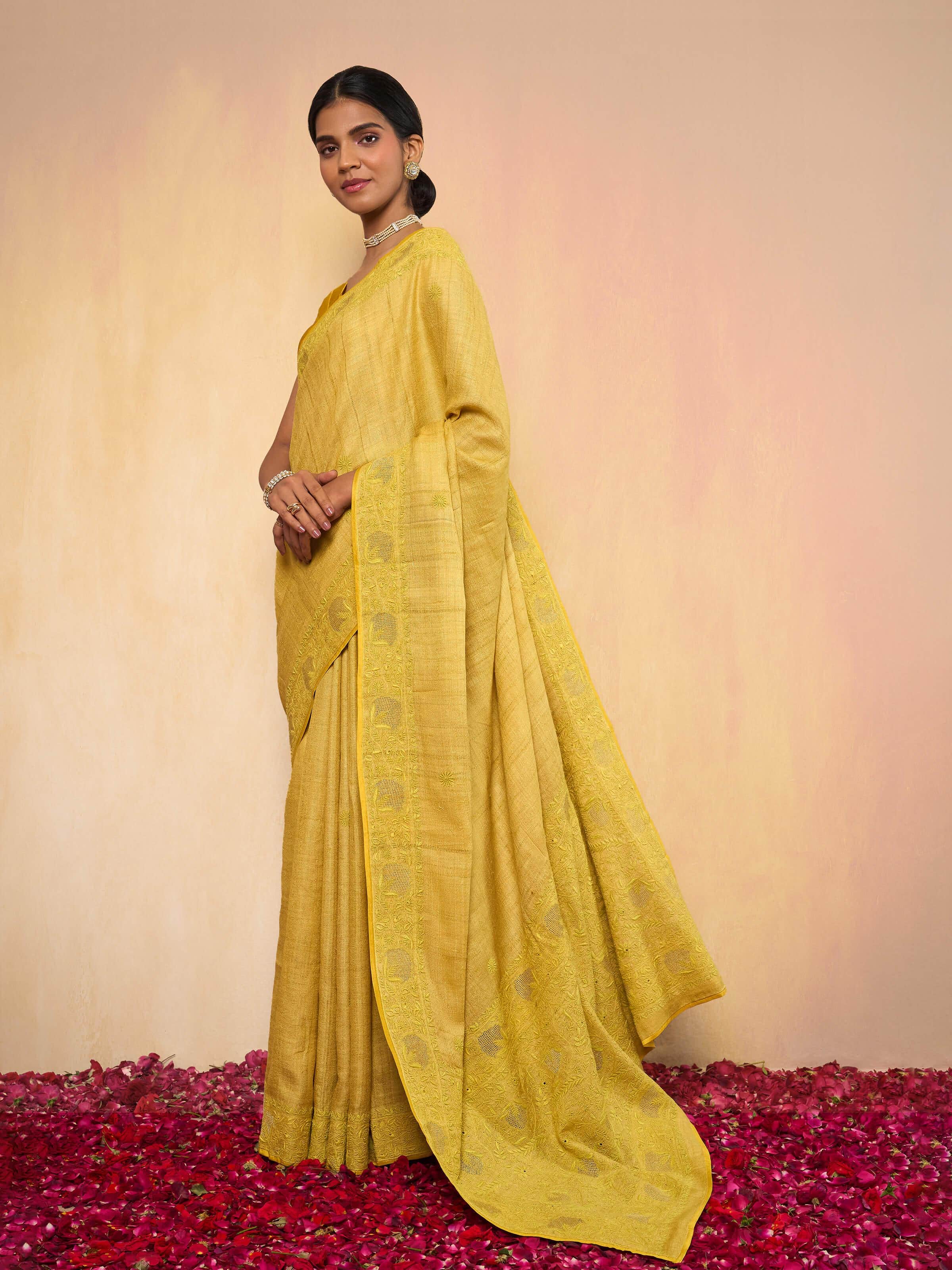 Lifestyle shot capturing the elegant drape and festive charm of the yellow silk chikankari saree.