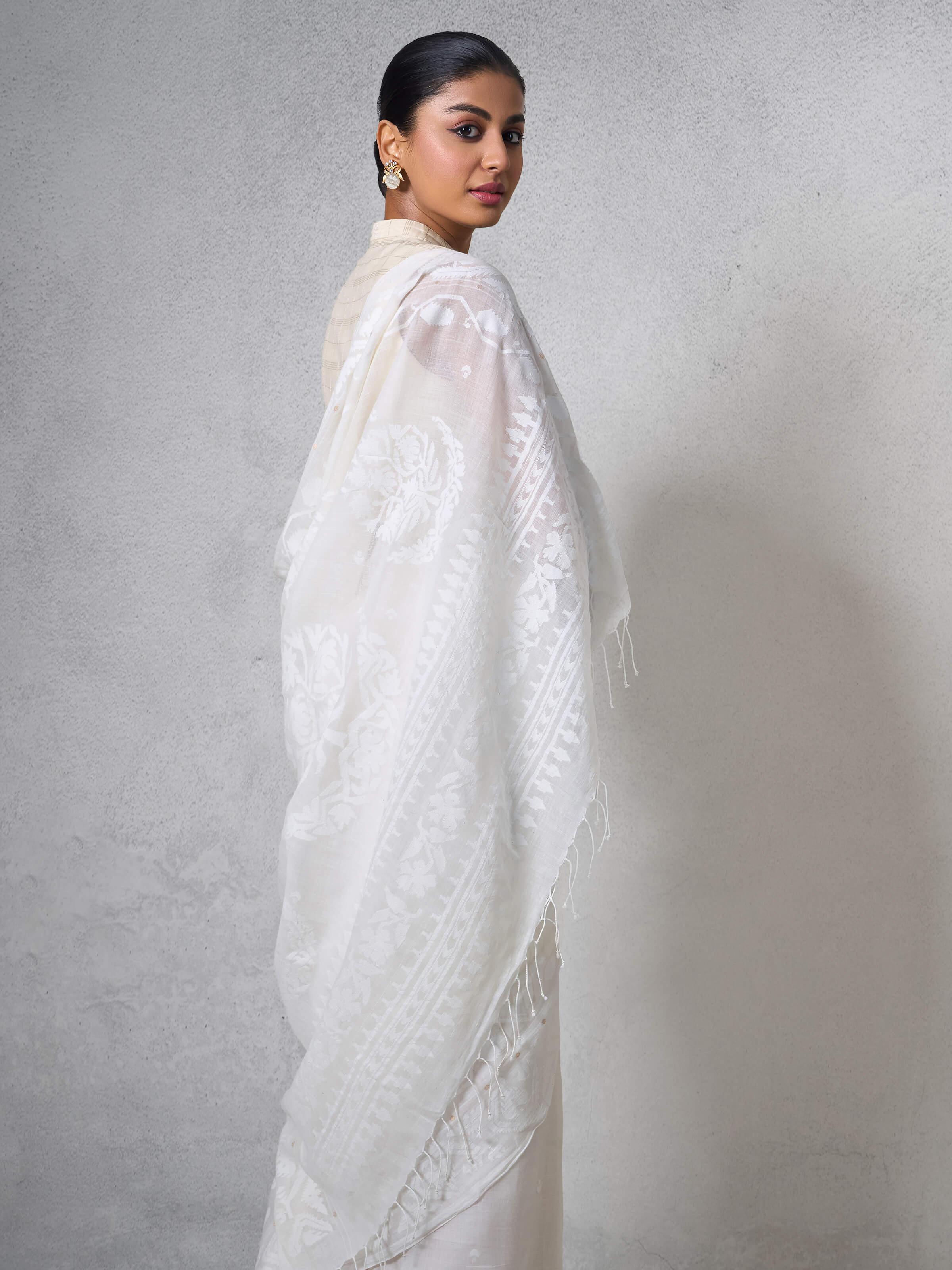 Angled view of sheer muslin drape and traditional Jamdani weaving.