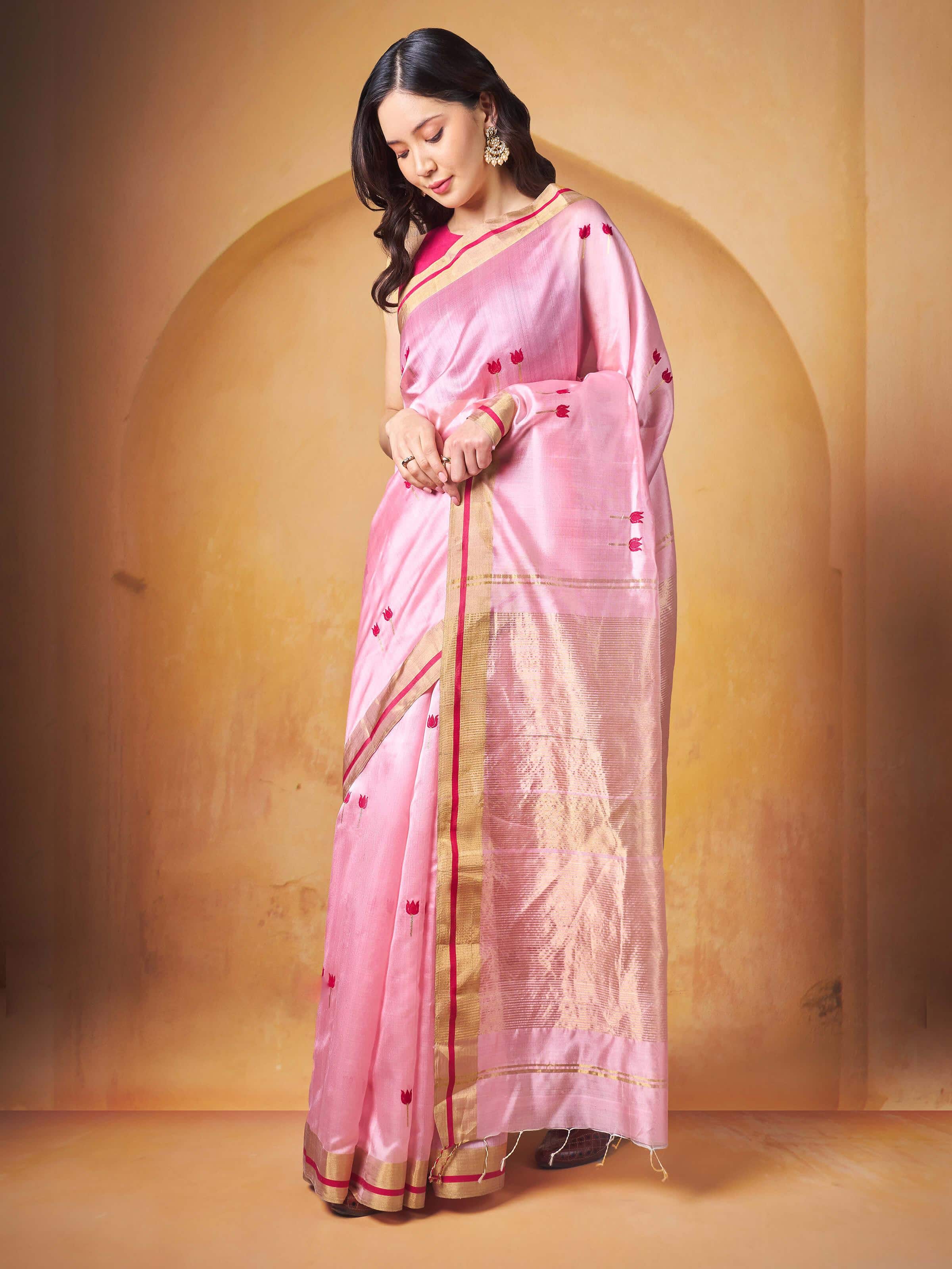 Lifestyle image of cream pink cotton silk Chanderi saree draped gracefully showcasing fabric sheen.