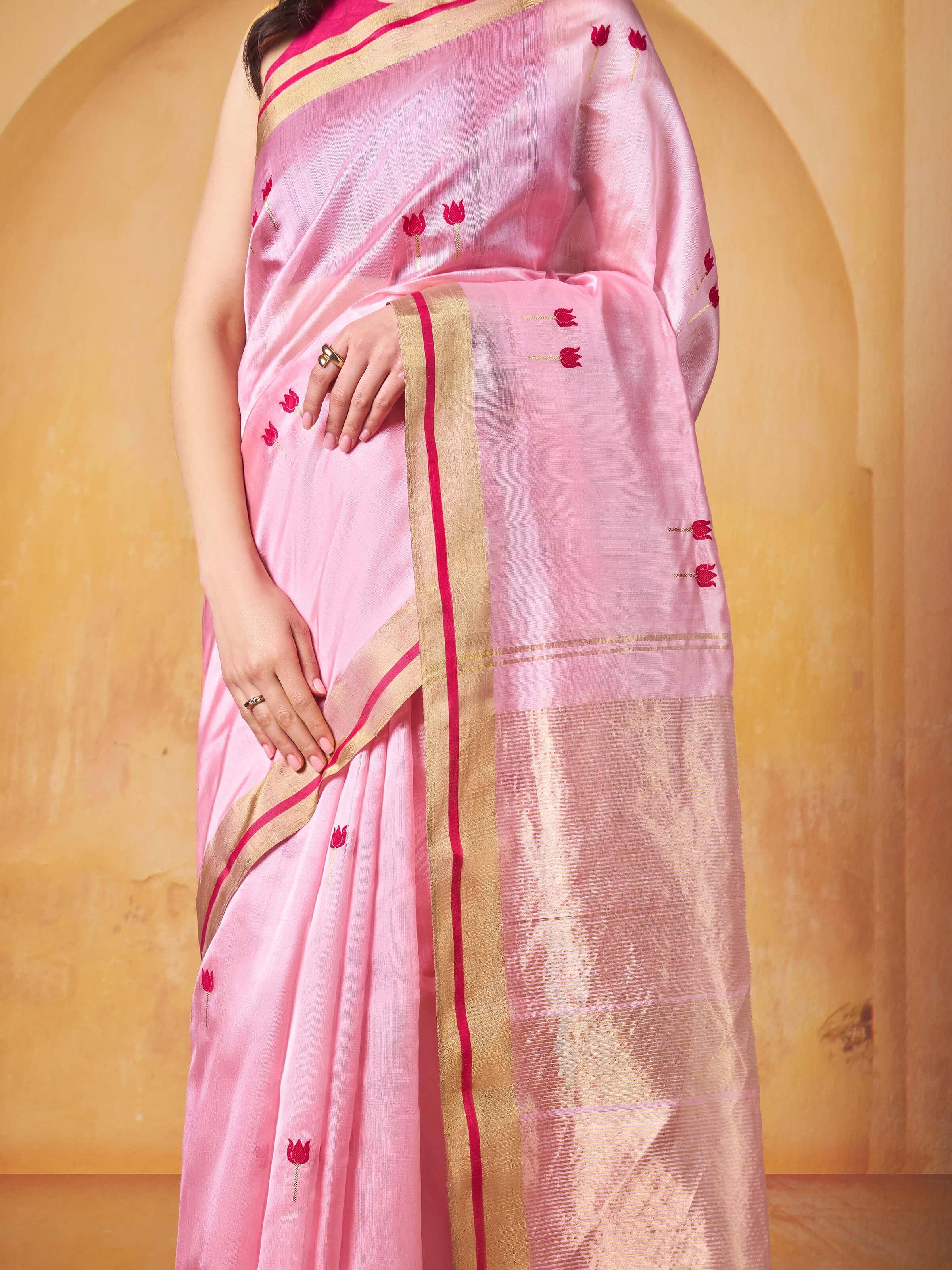 Detailed close-up of fabric texture and zari border on cream pink Chanderi saree.