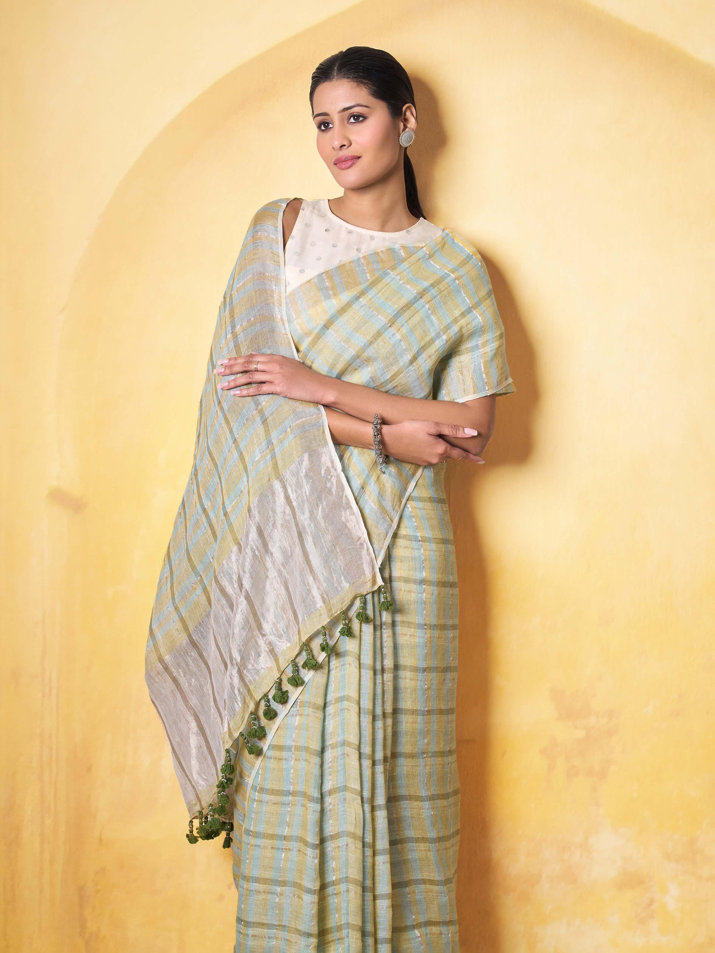 Angled view emphasizing fine linen weave and zari embroidery on saree pallu