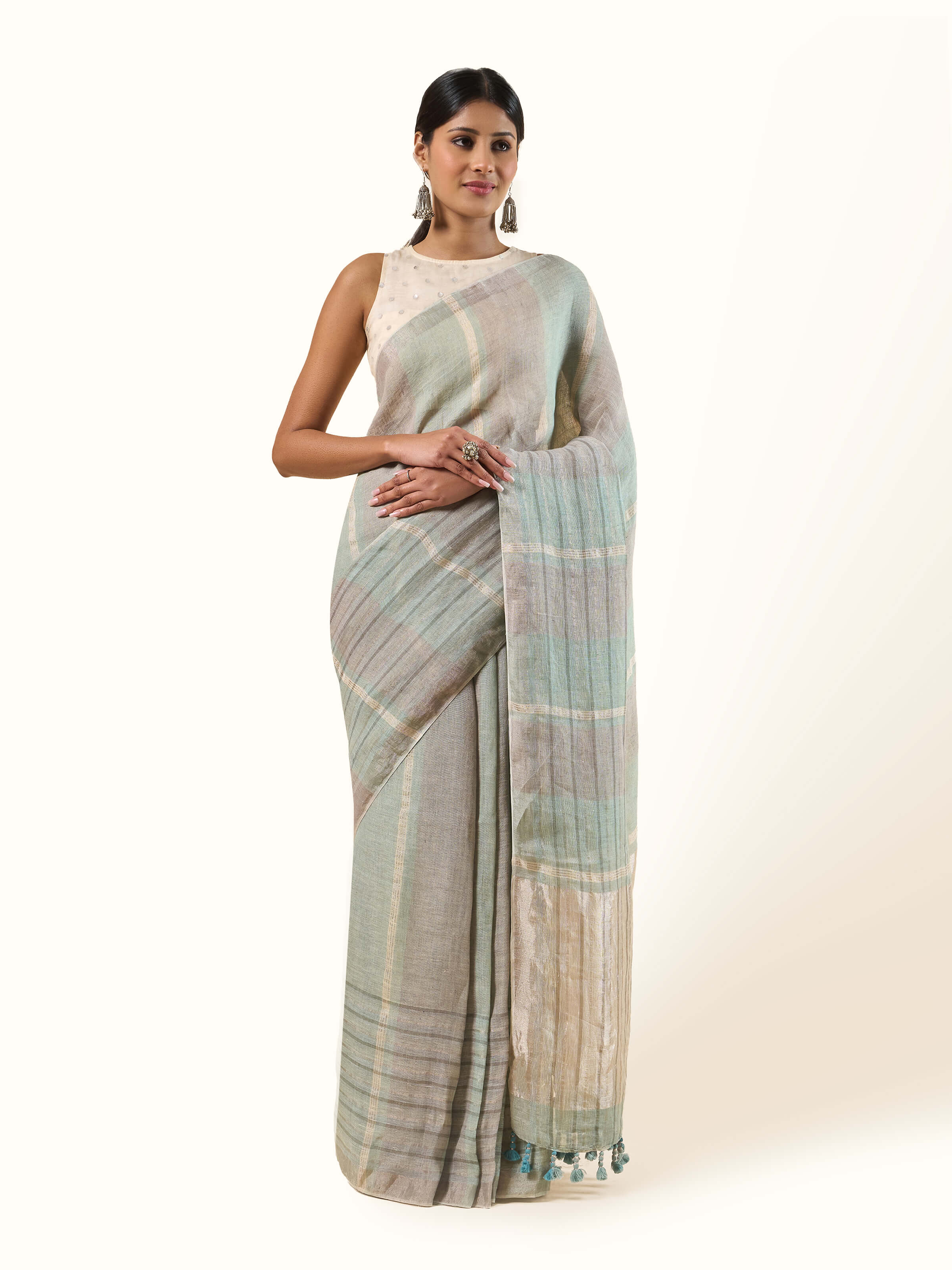 Front view of the light green linen saree accented by delicate Zari threads.
