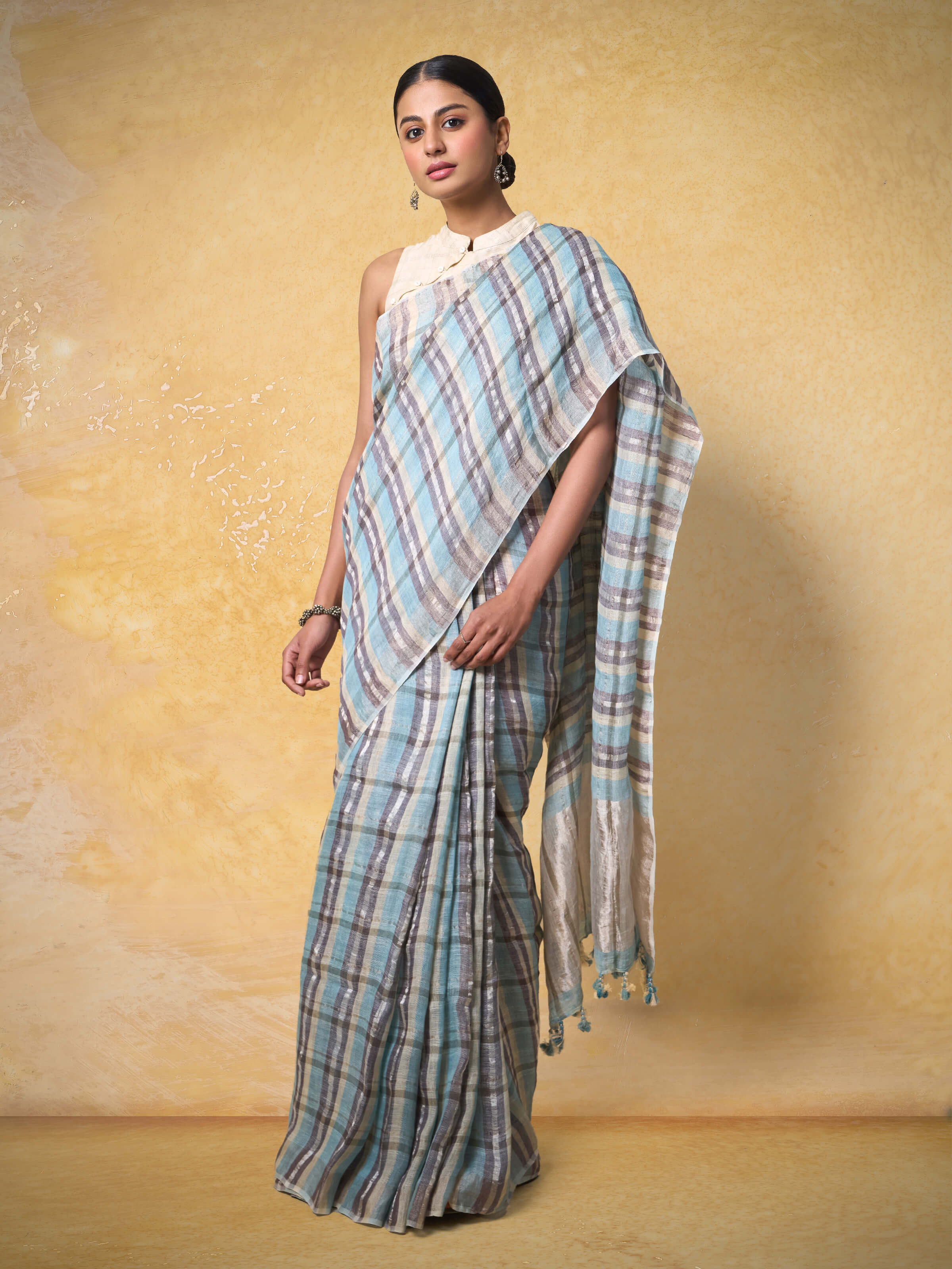 Model gracefully draped in grey linen Zari saree highlighting its rich texture and traditional finish.