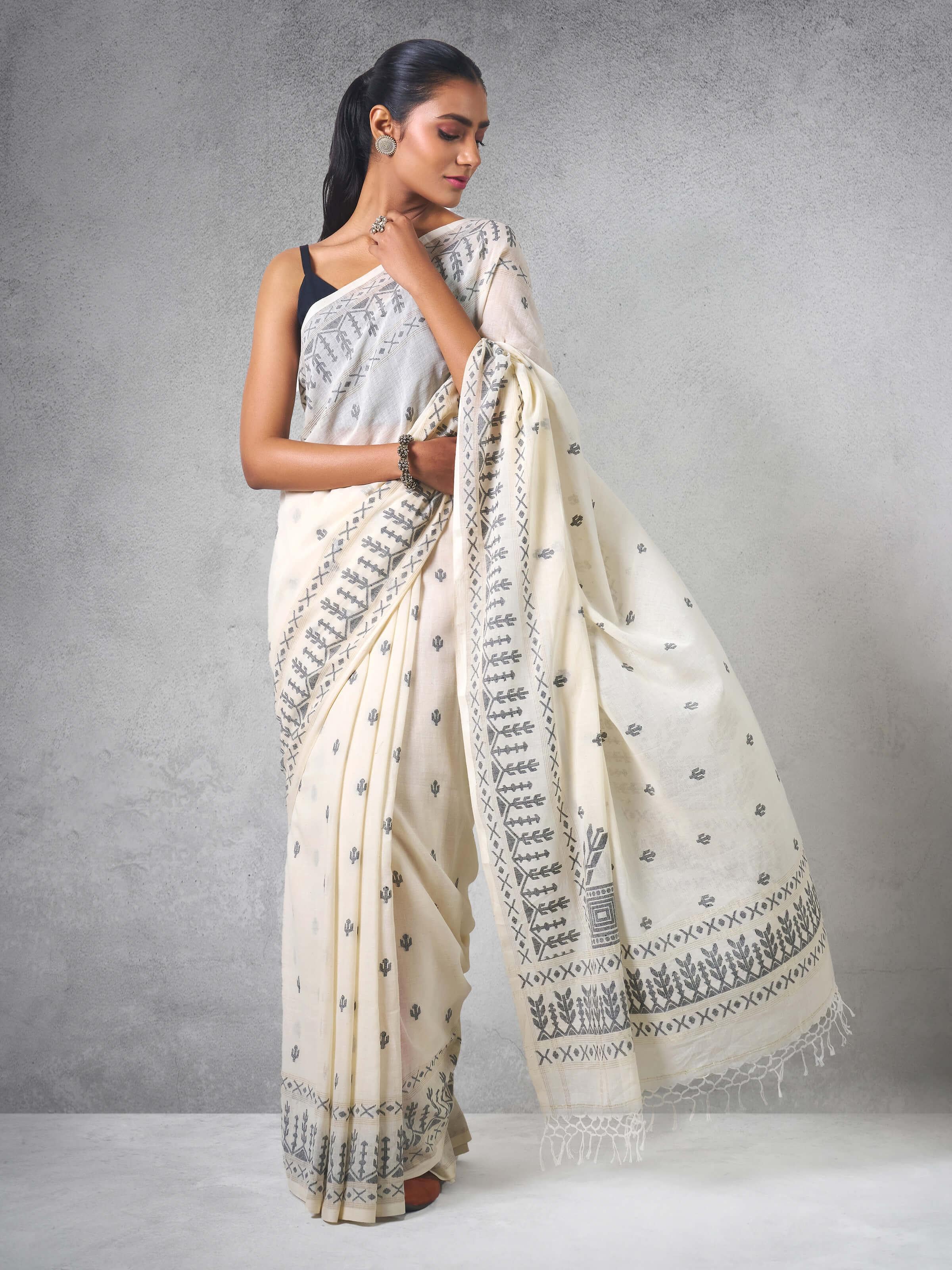 Lifestyle view of off-white cotton Jamdani saree styled with minimal jewelry.