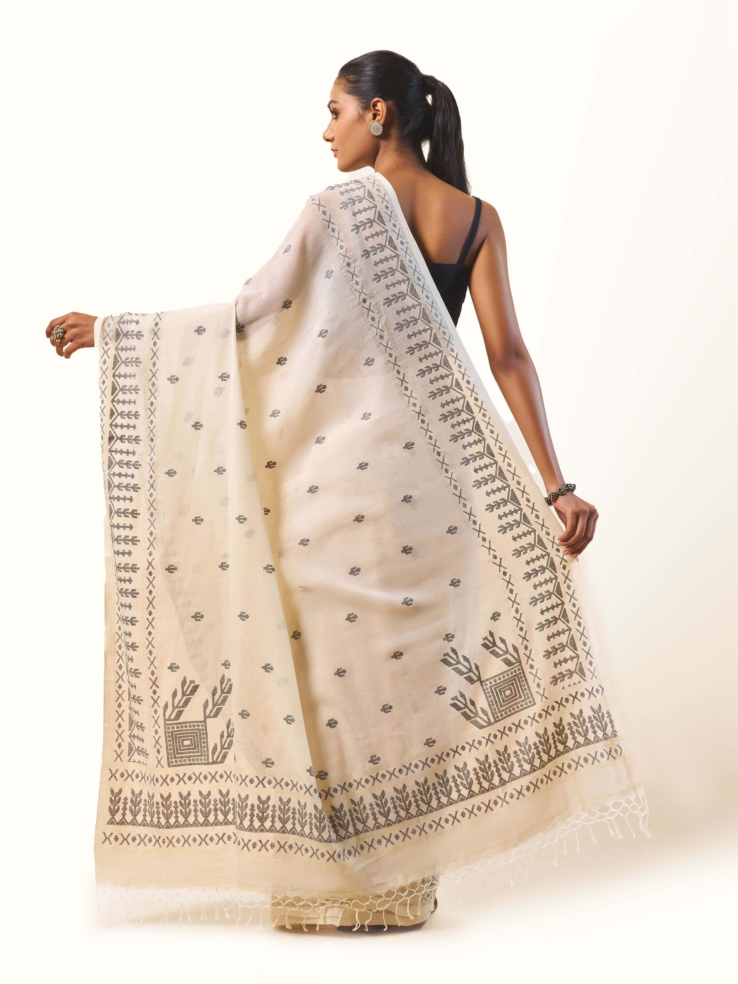 Back view of off-white cotton Jamdani saree with trailing pallu.