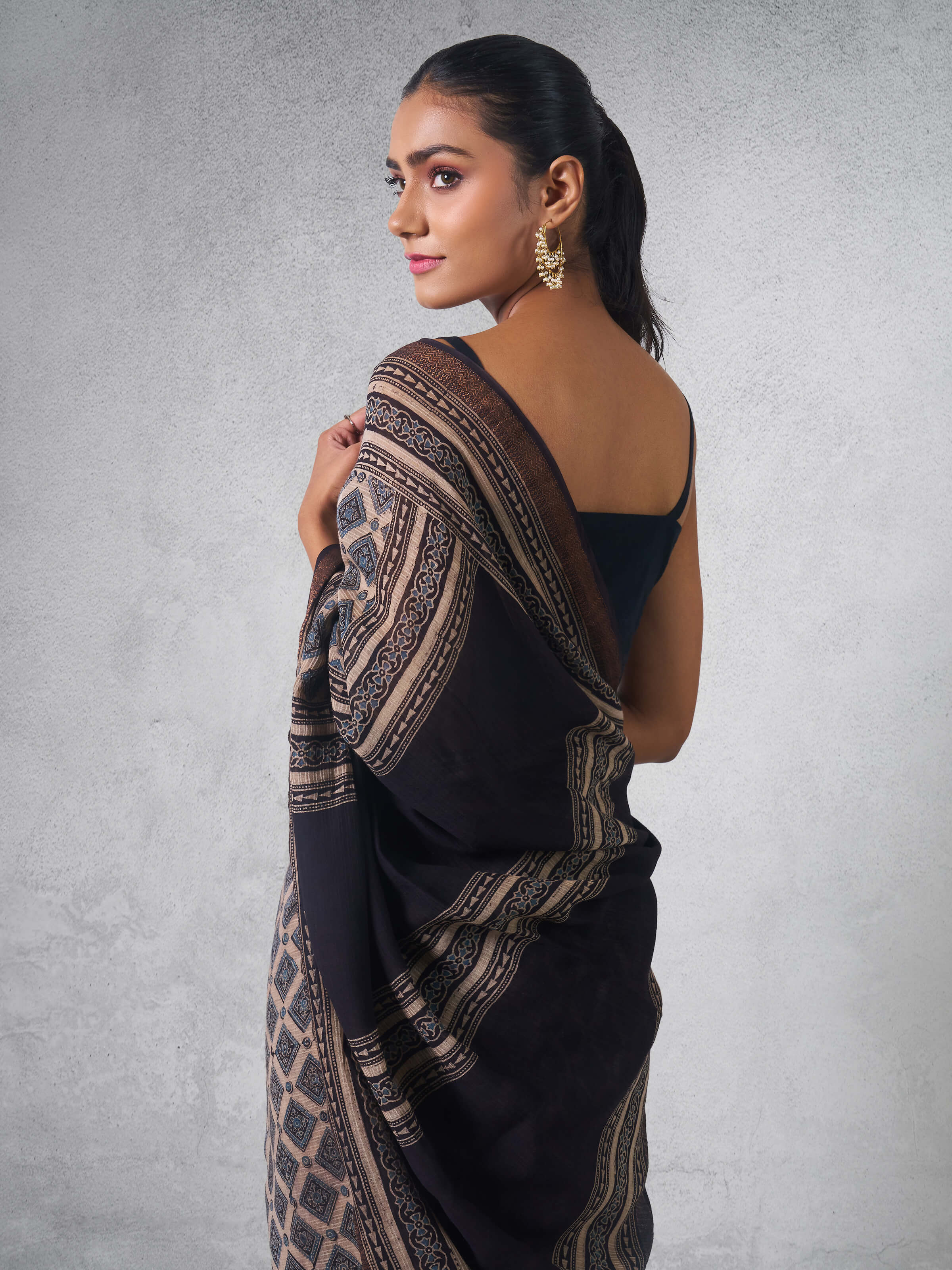 Angled view of Ajrakh saree in black Maheshwari weave showing fine block detailing