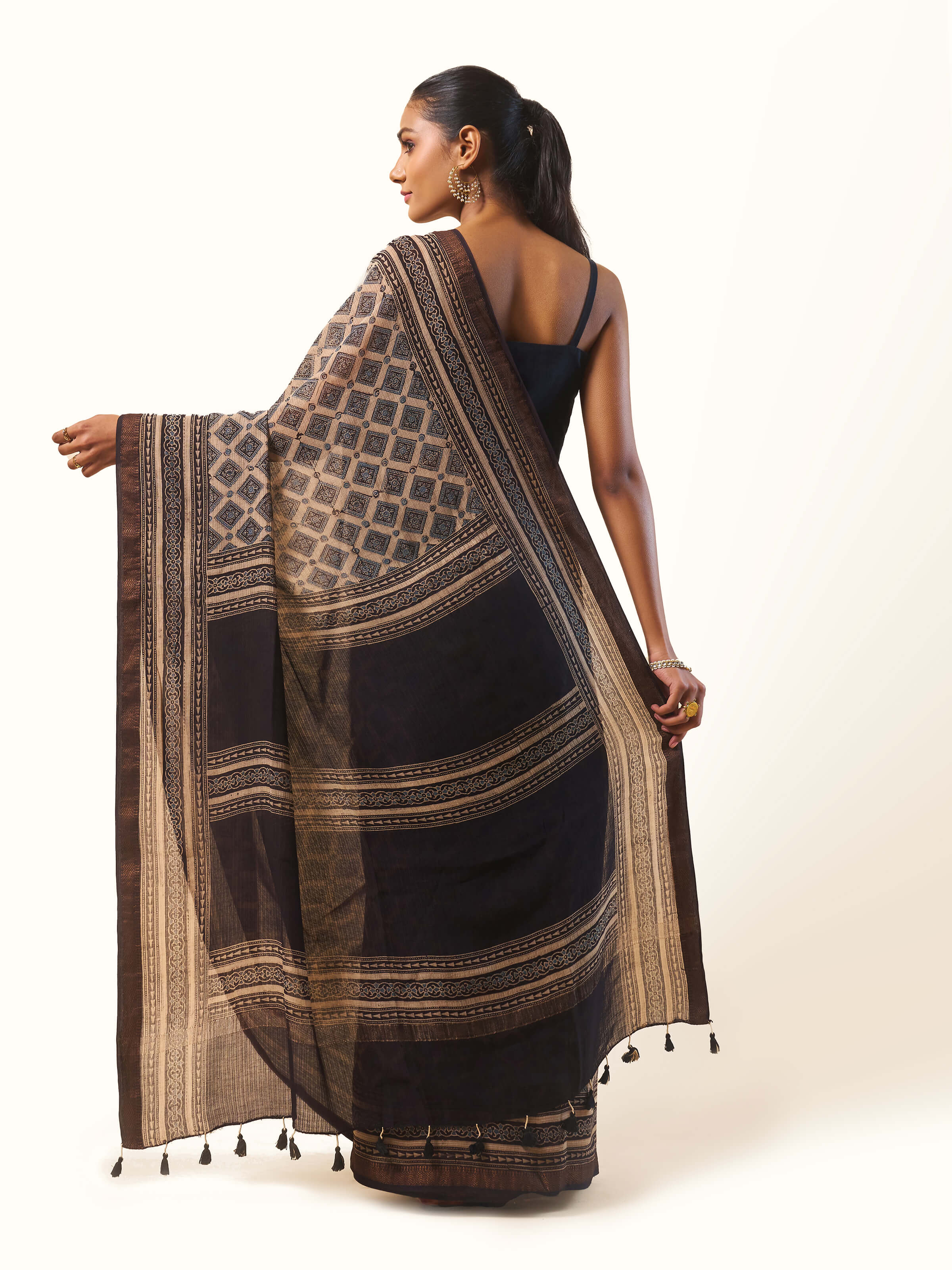 Back view of black Ajrakh block print saree displaying pallu layout and soft fall