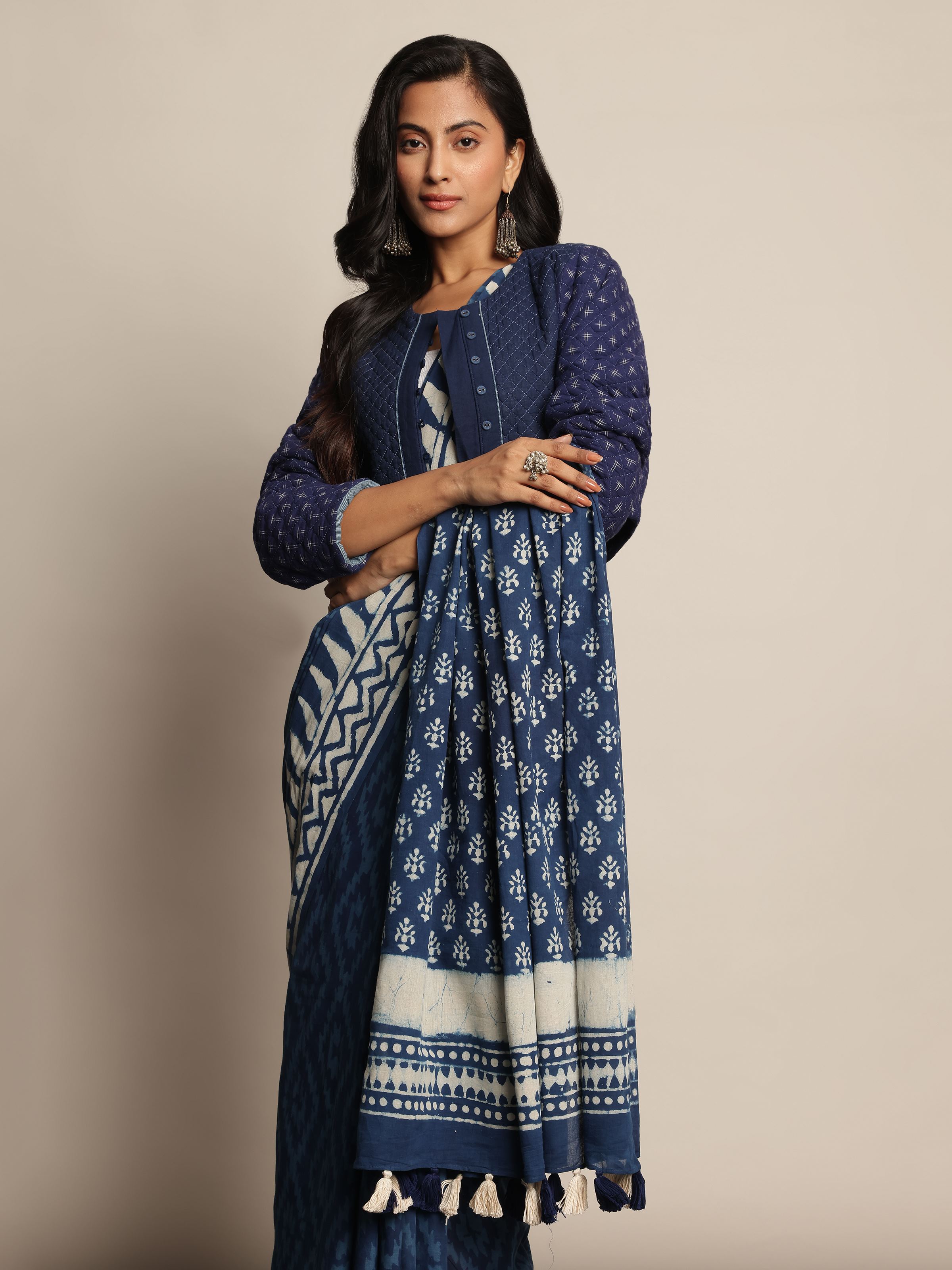 Front view of model wearing blue & white Dabu printed saree styled in a casual ethnic look.