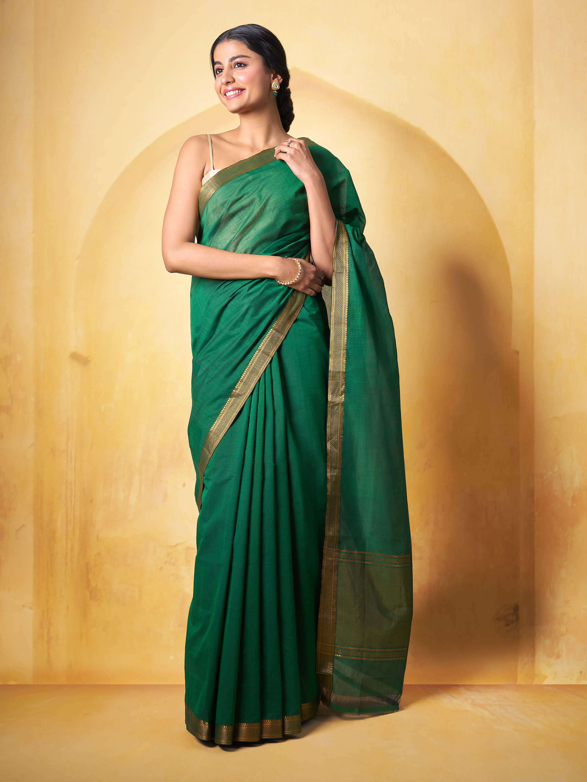 Lifestyle image of dark green cotton Mangalgiri saree draped elegantly highlighting fabric flow and natural dye.