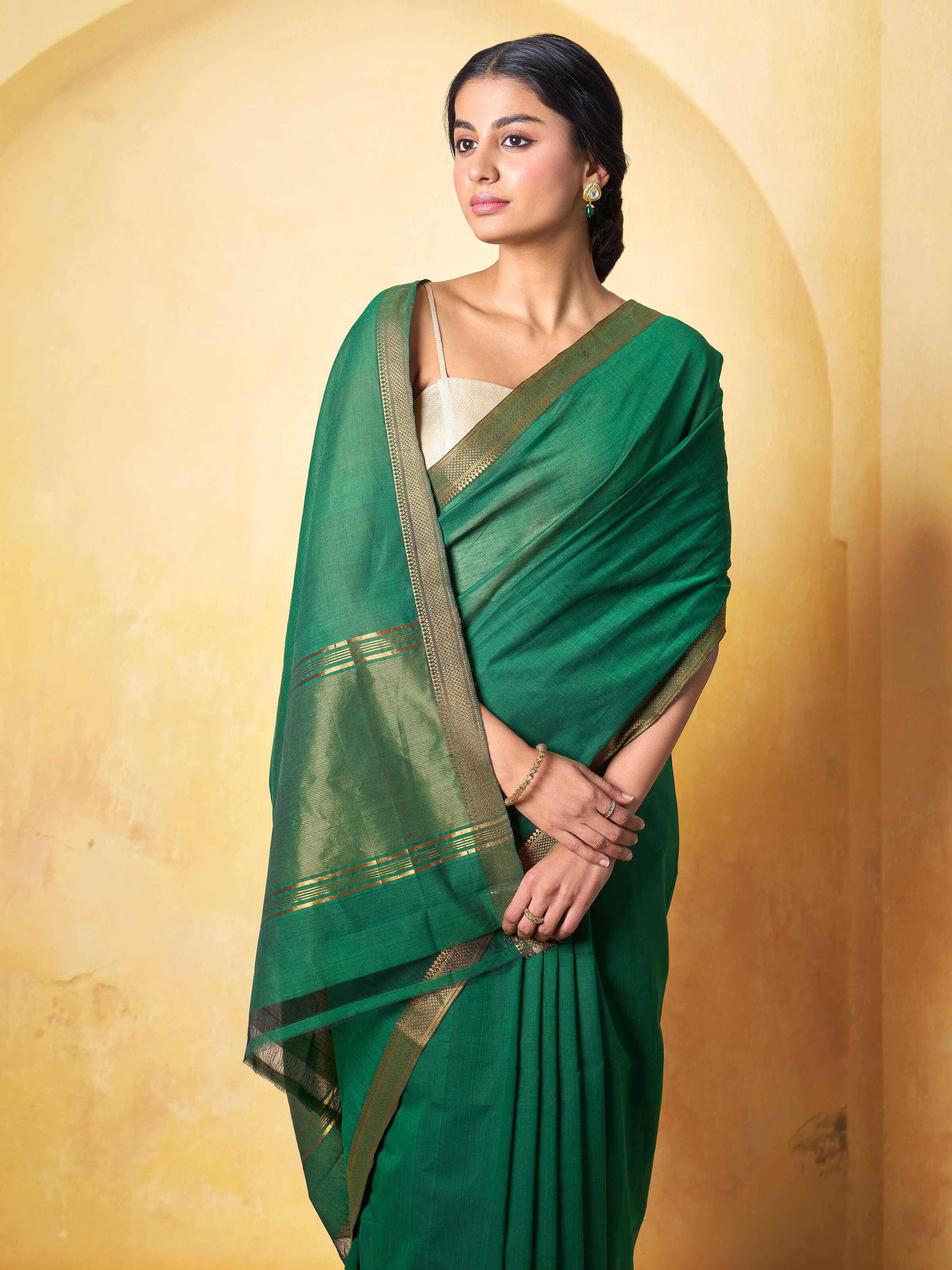Detailed close-up of dark green cotton Mangalgiri saree fabric showing handwoven texture.