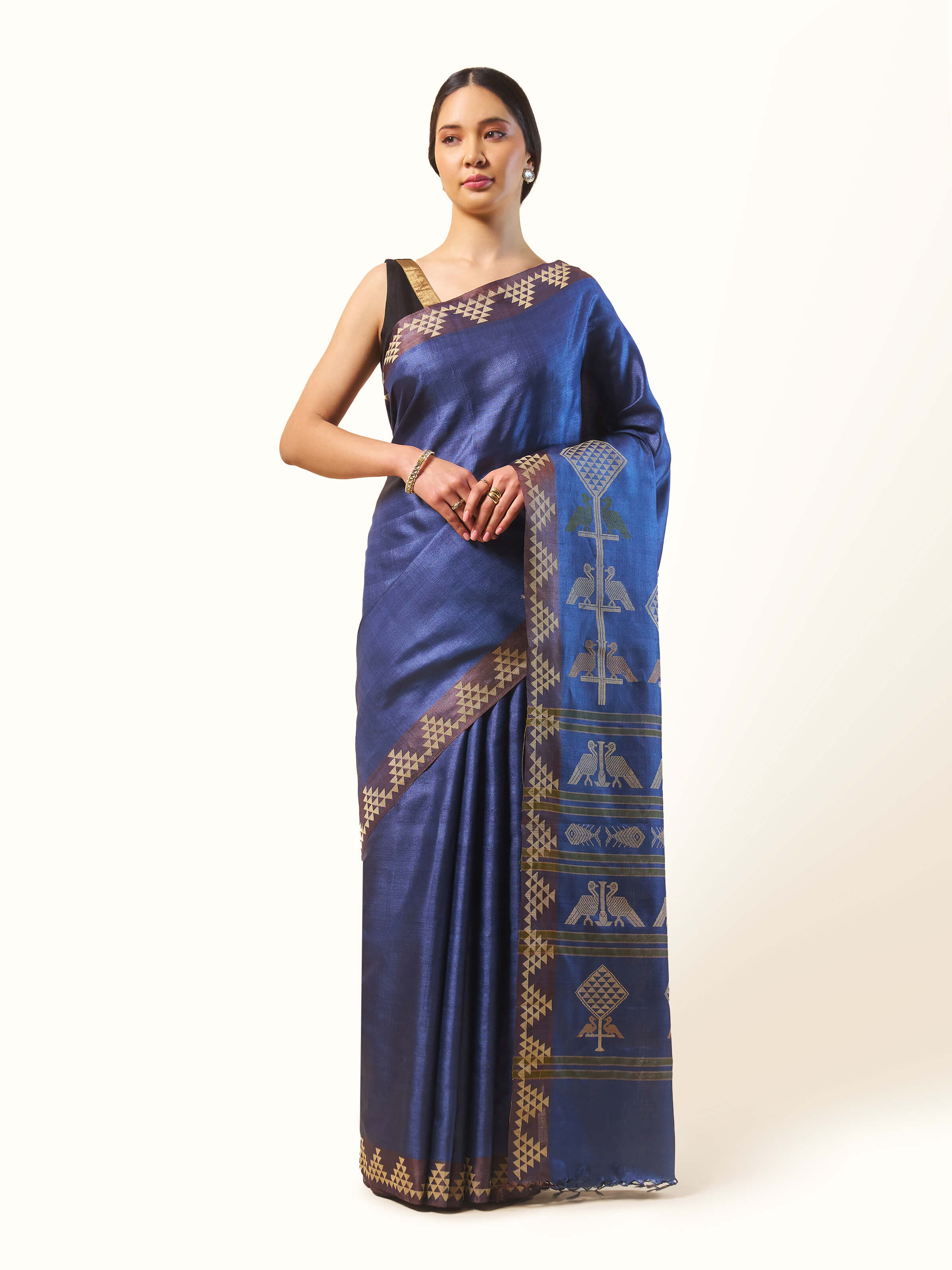 Front view of dark blue Tussar silk saree with extra-weft woven motifs.