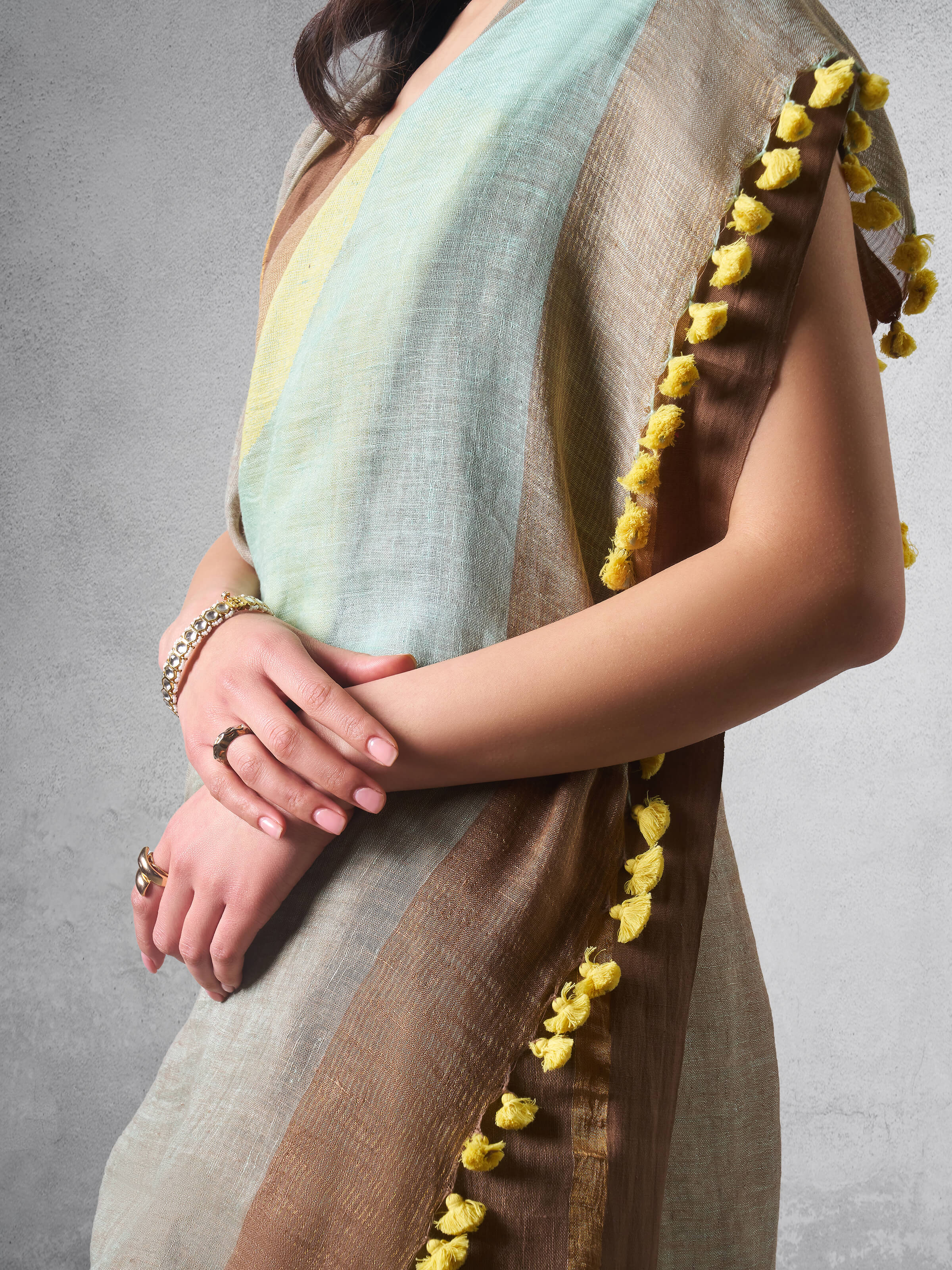 Close-up of linen cotton weave and saree border detail in beige saree.