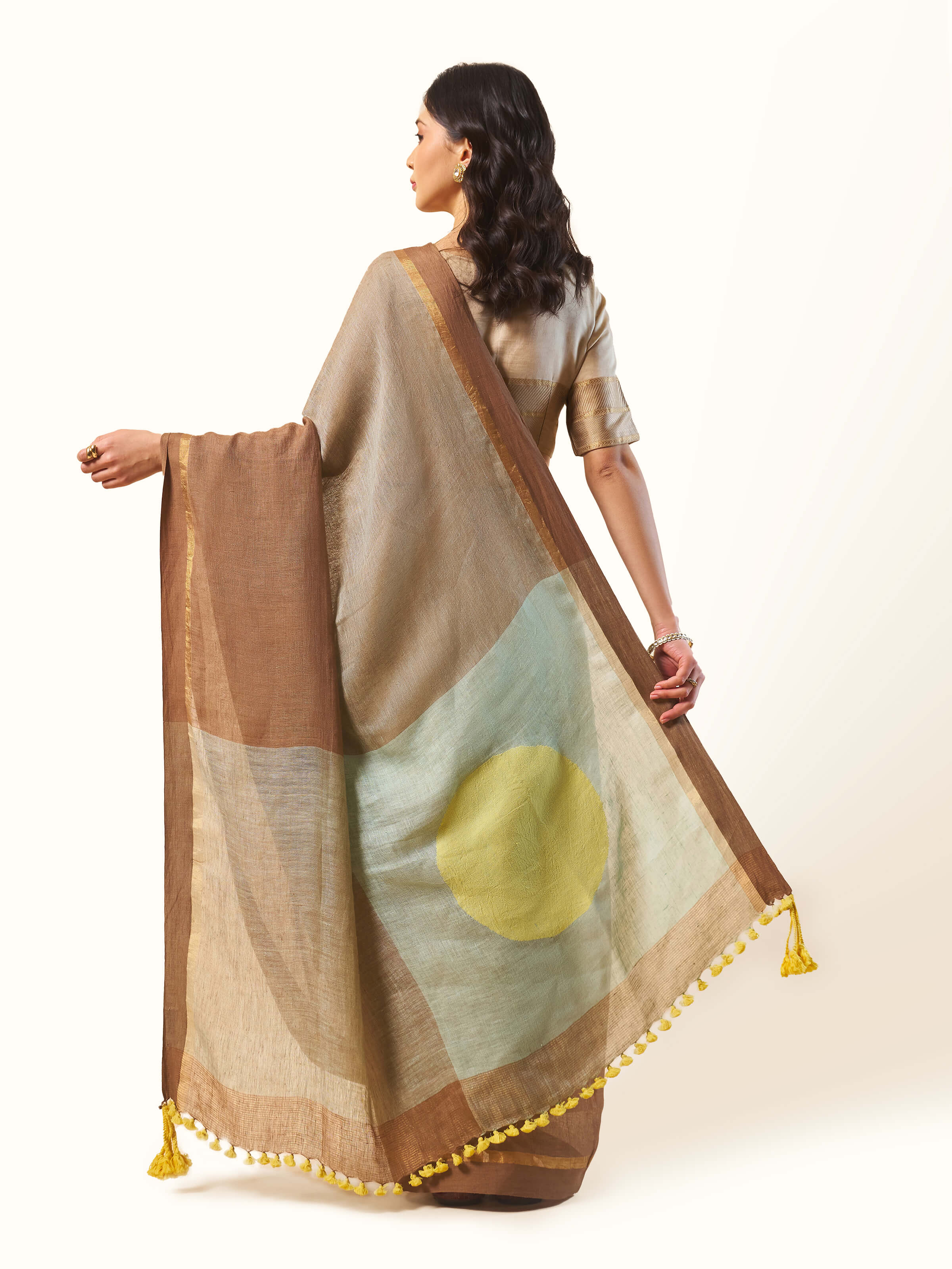 Back view of beige linen cotton saree showing pallu fall and stitching finish.