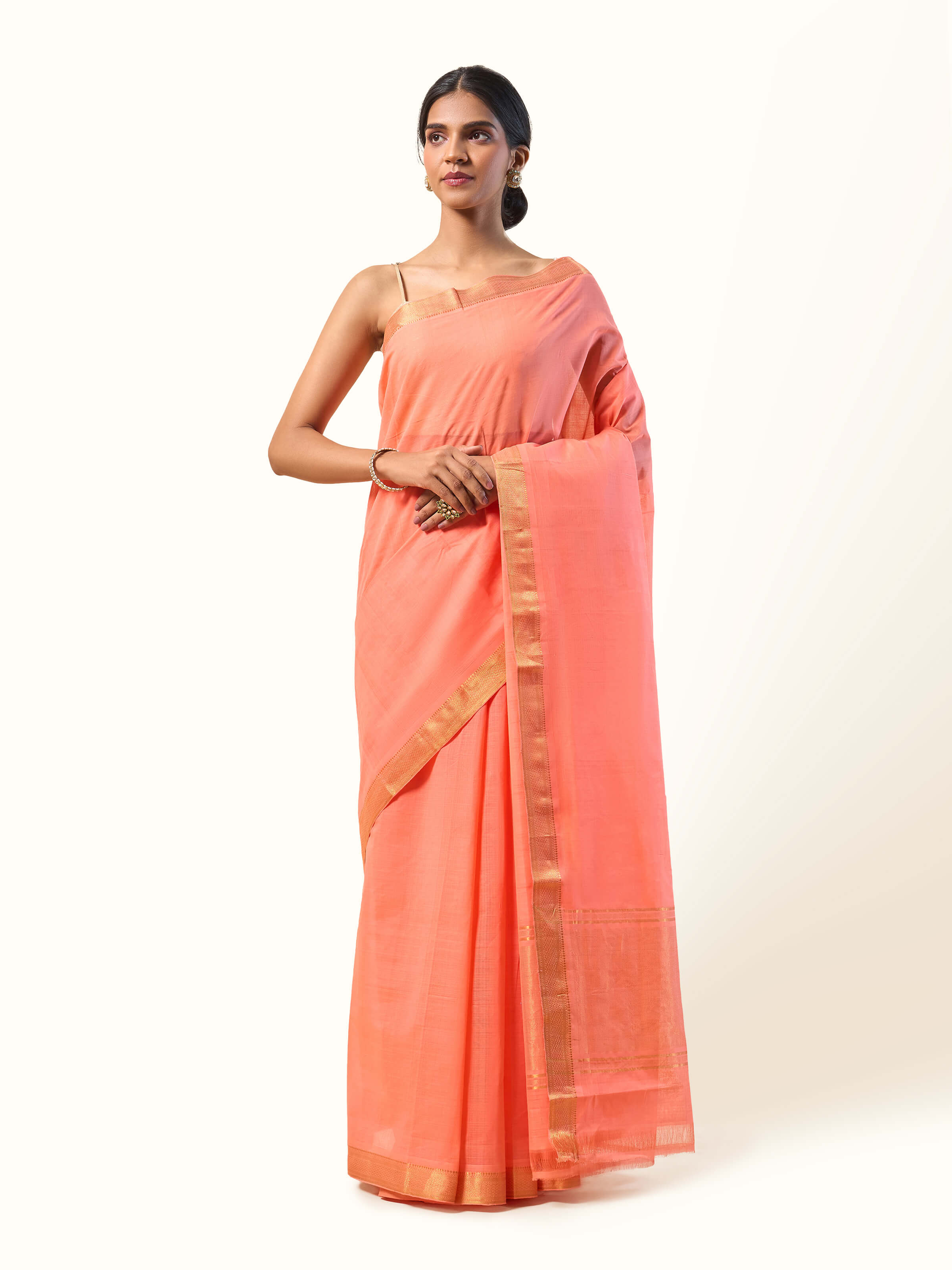 Front view of peach cotton Mangalgiri saree featuring traditional striped border and fine weave.
