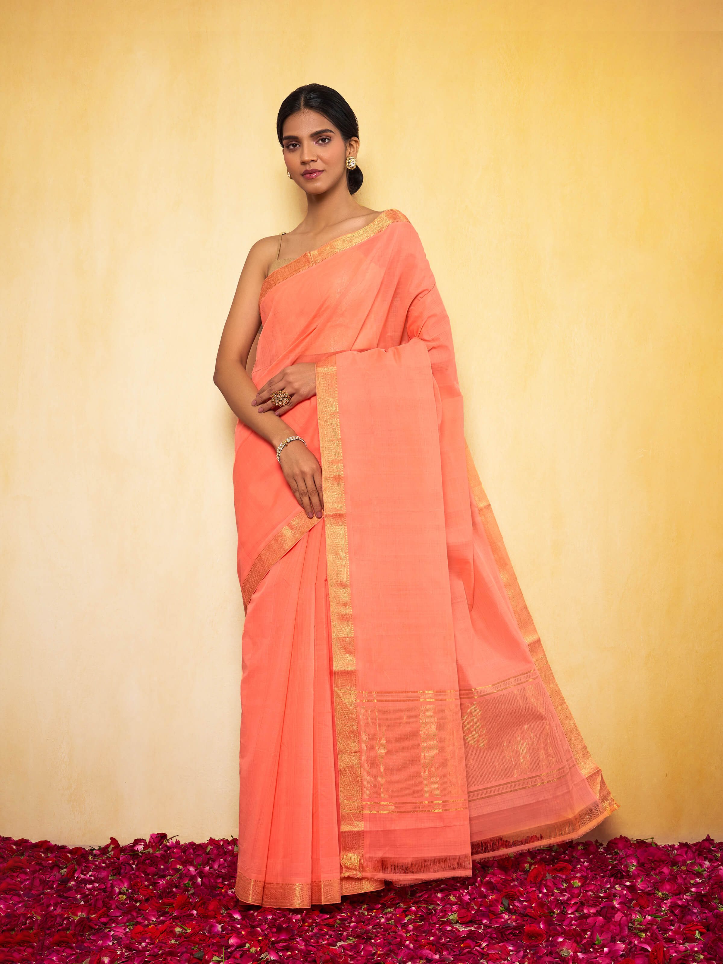 Lifestyle view of peach Mangalgiri saree styled in an ethnic look with minimal jewelry.